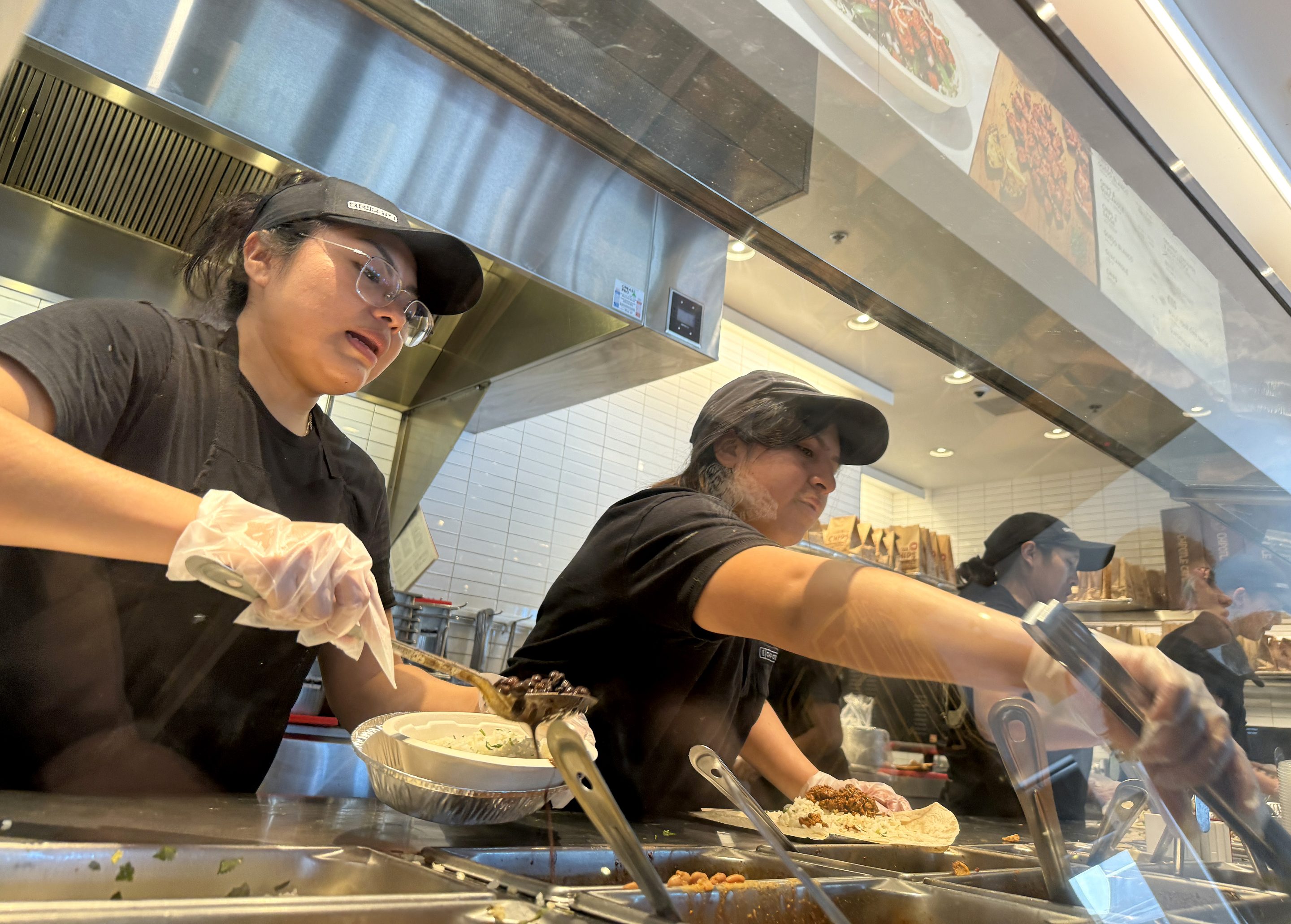 Chipotle workers making burrito bowls