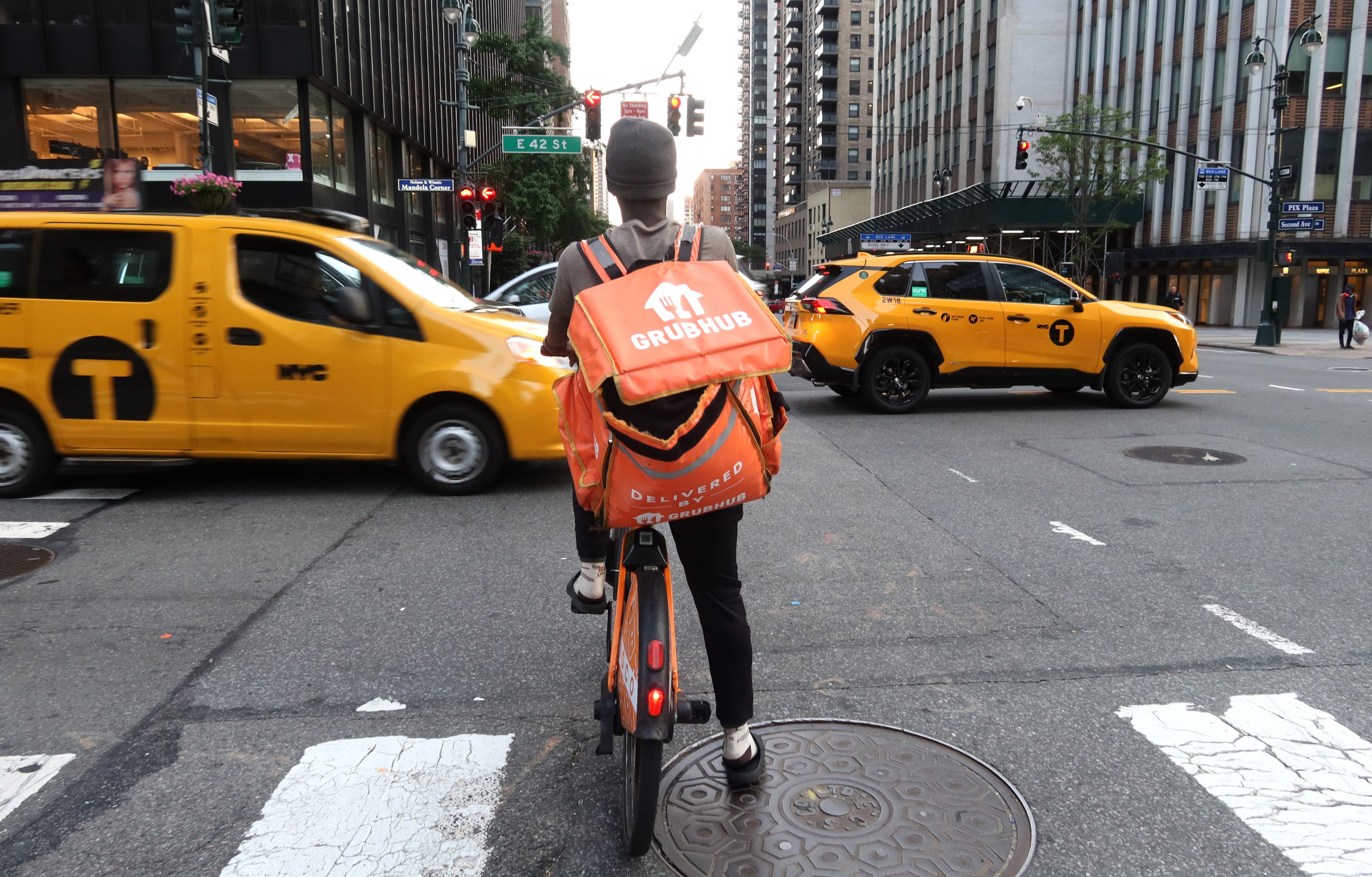 A delivery person for GrubHub rides an e-bike along Third Avenue on June 13, 2024, in New York City.
