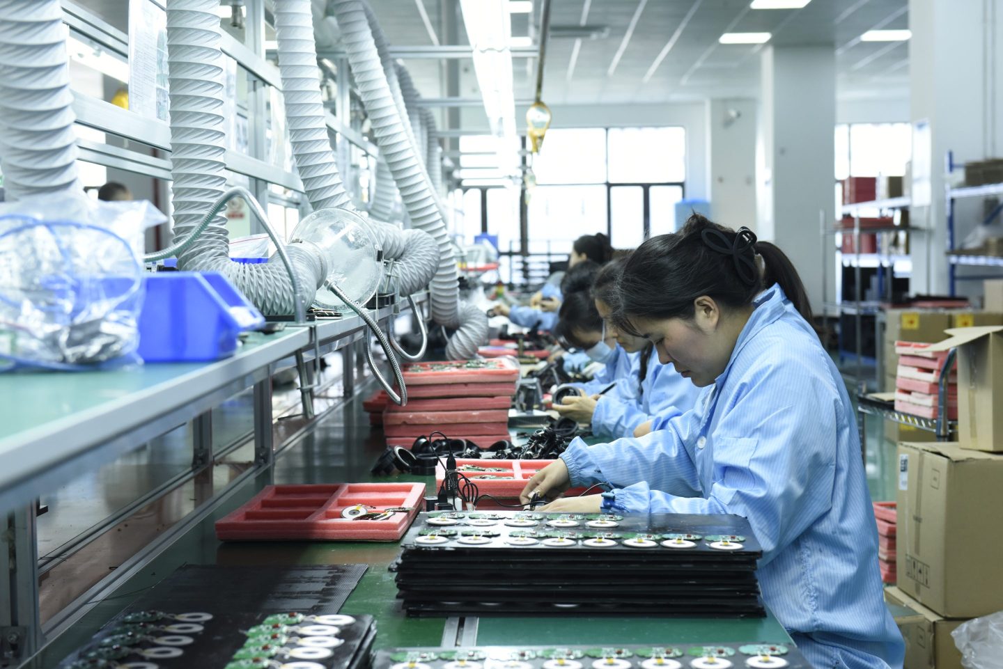 Workers install chips, resistors, and other components on a circuit board in a workshop in Fuyang, Anhu province, China on Nov. 30, 2024.