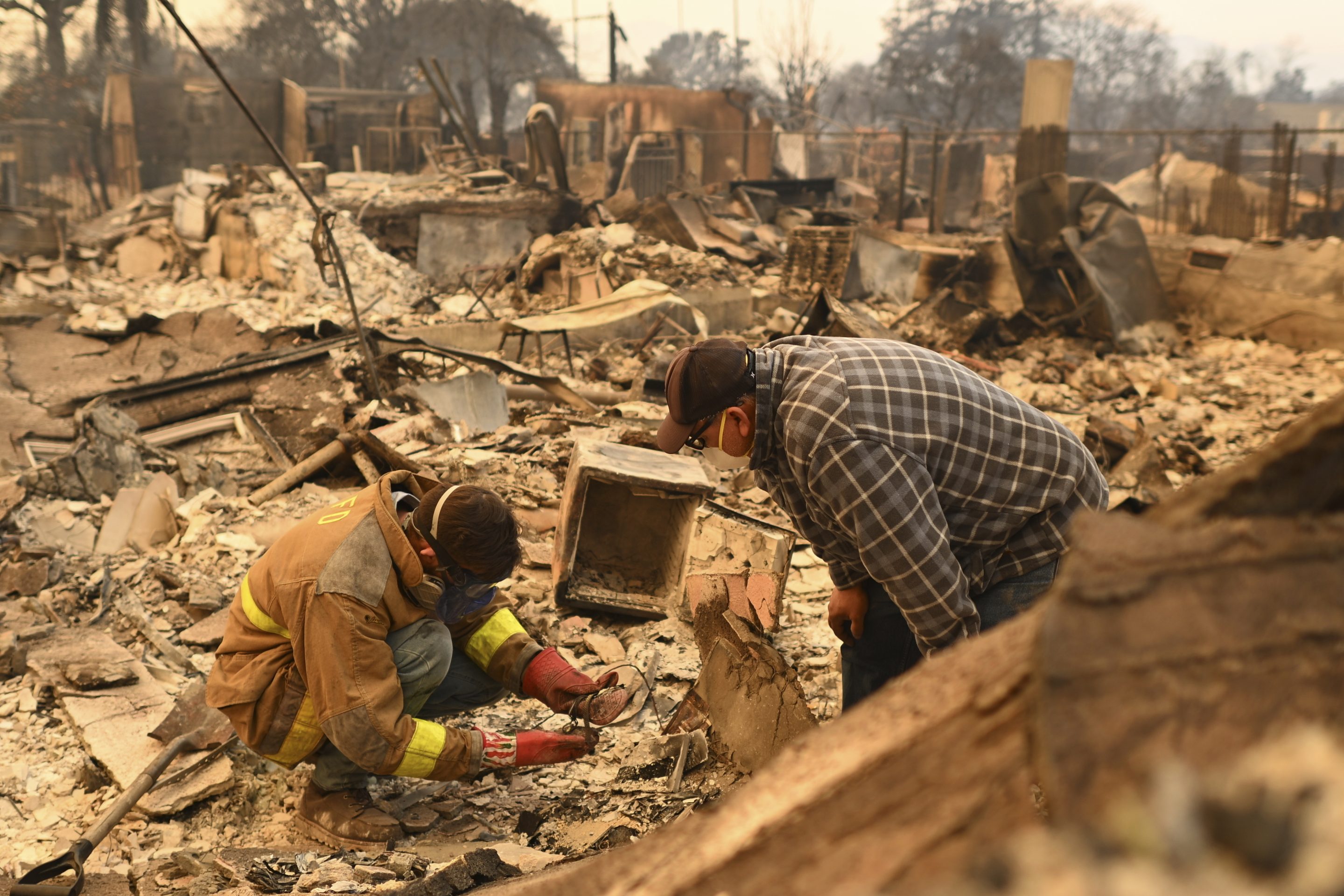 Robert Lara, left, looks for belongings along with his stepfather after the Eaton Fire burns in Altadena, Calif., on Jan. 9, 2025.