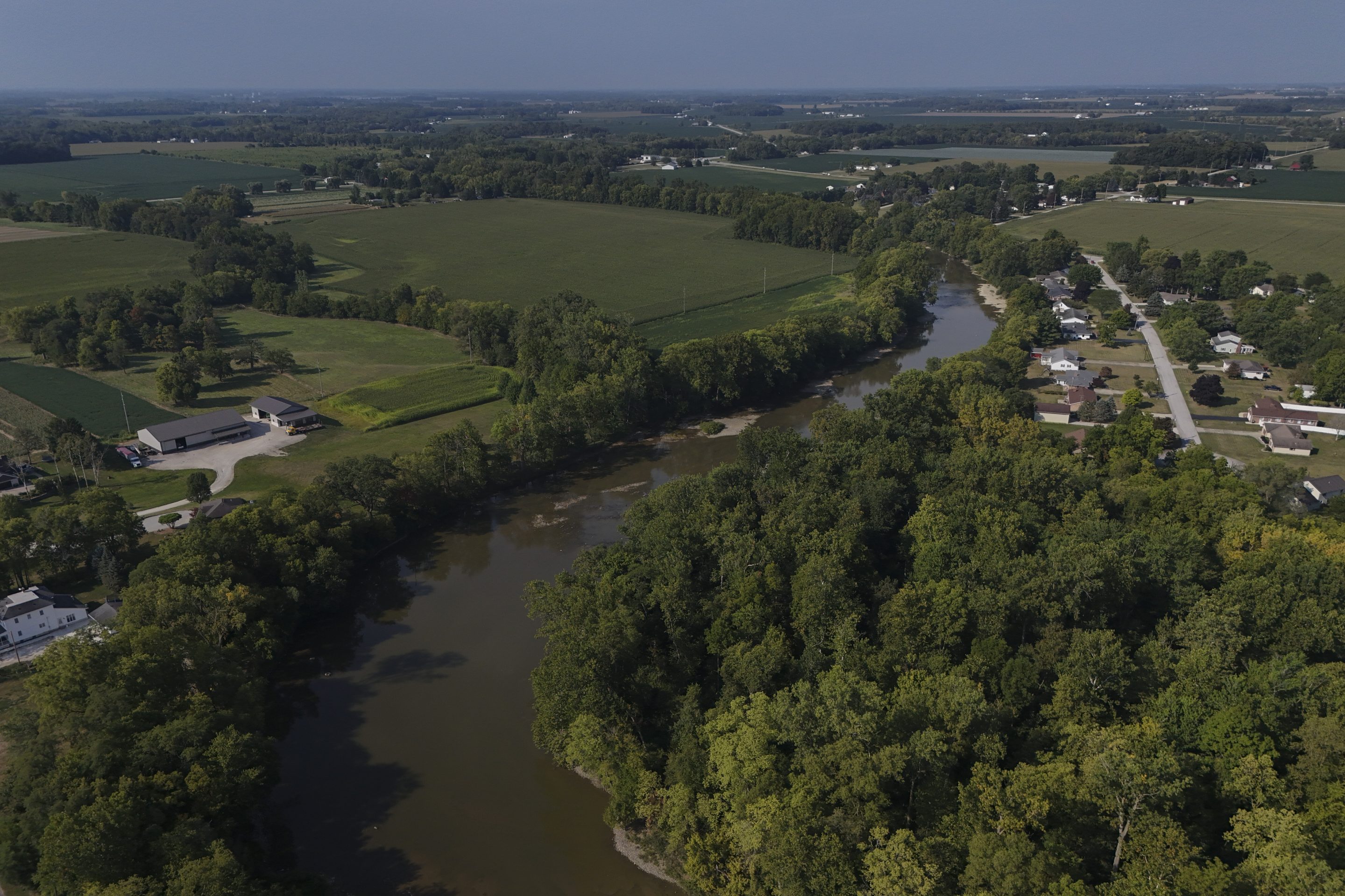 Water flows down the Sandusky River between farms, Aug. 26, 2024, in Fremont, Ohio.