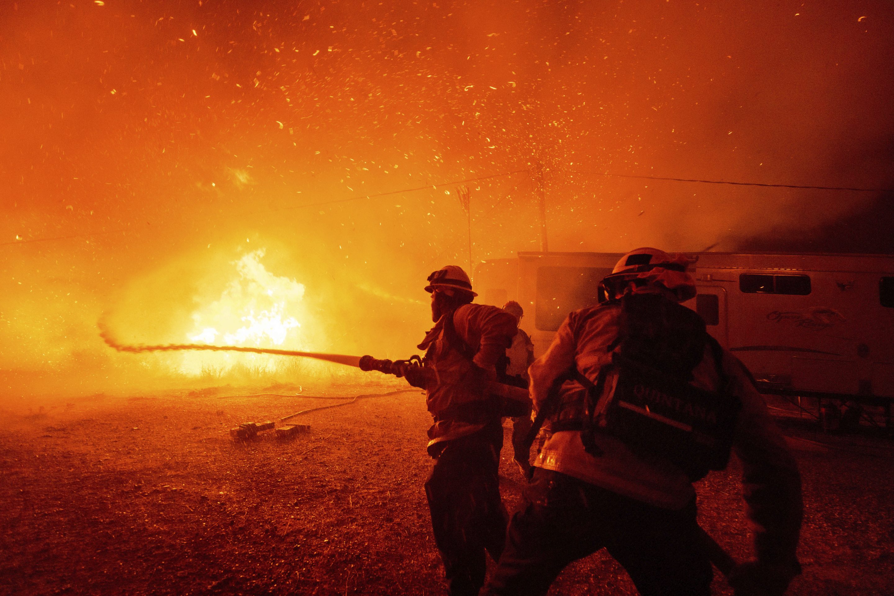 Firefighters spray water on the Hughes Fire in Castaic, Calif., on Jan. 22, 2025.