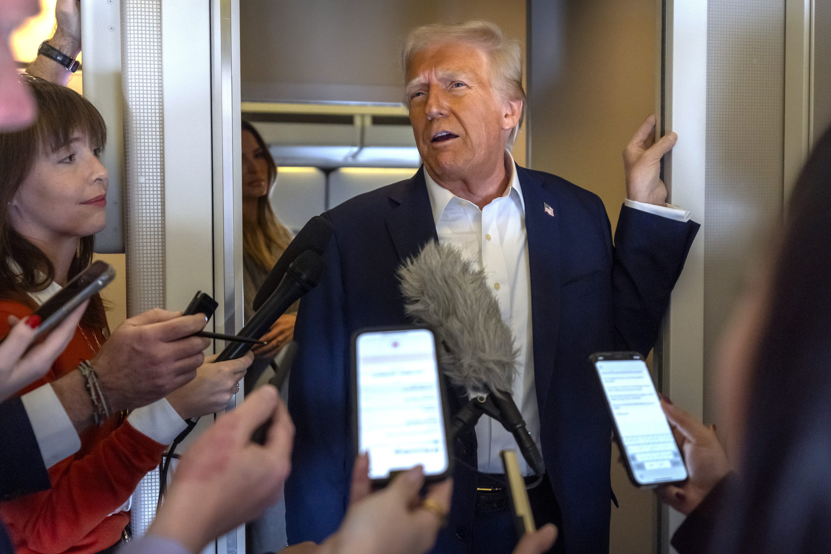President Donald Trump speaks to reporters aboard Air Force One as he travels from Las Vegas to Miami on Saturday.