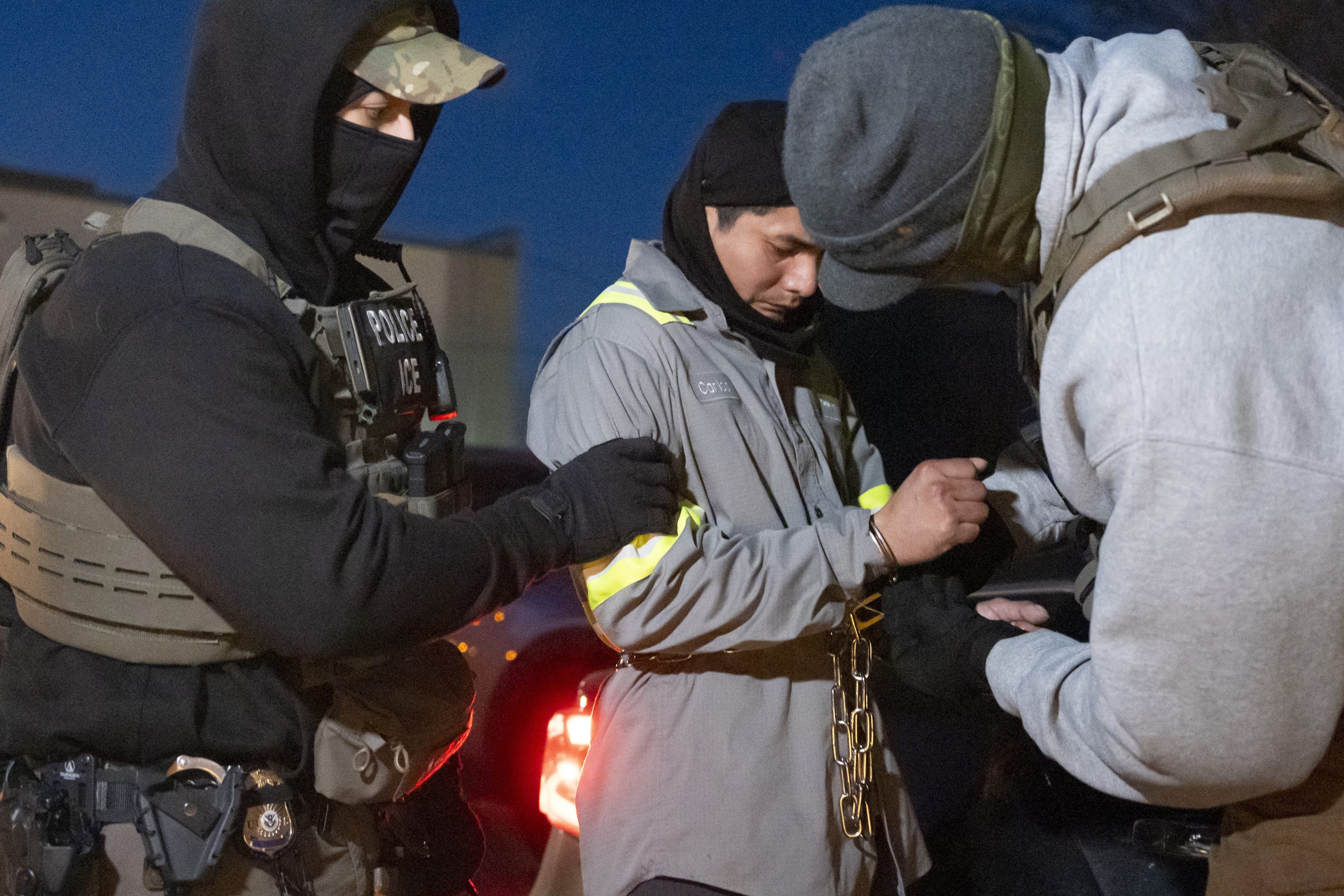 U.S. Immigration and Customs Enforcement officers use a chain to more comfortably restrain a detained person using handcuffs positioned in front, on Jan. 27, 2025, in Silver Spring, Md.