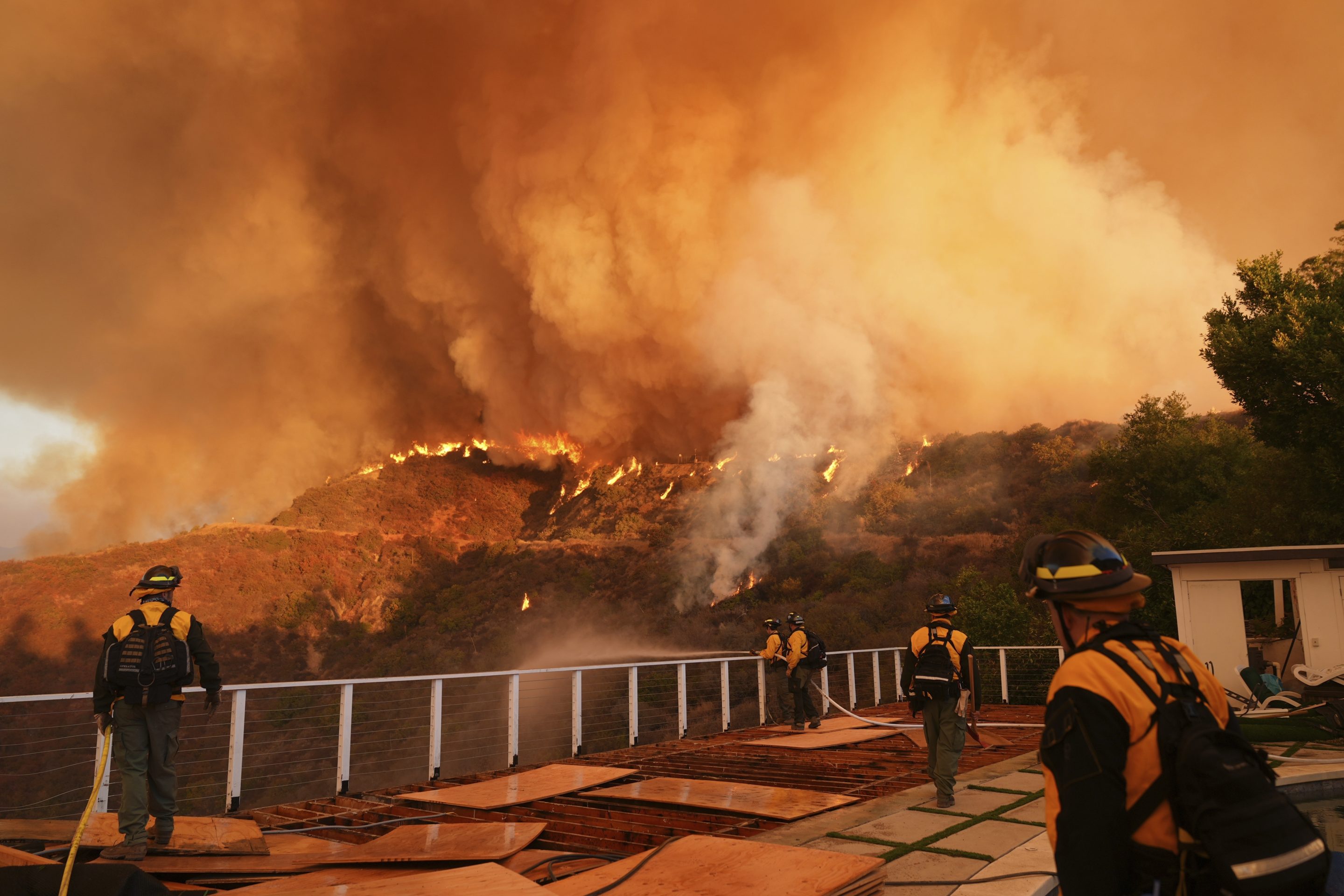 Fire crews monitor the Palisades Fire in Mandeville Canyon, Jan. 11, 2025, in Los Angeles.