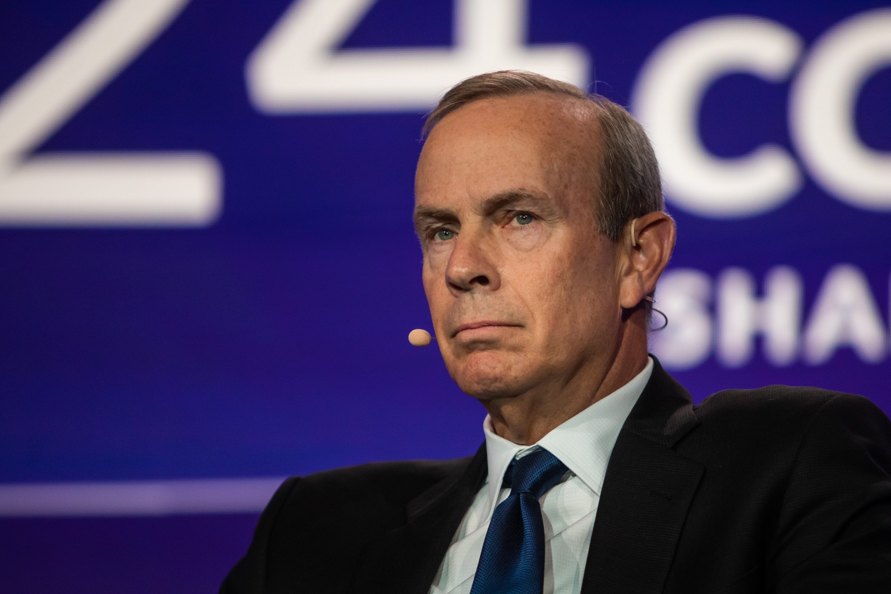 Chevron's CEO sitting in a chair, looking not too thrilled