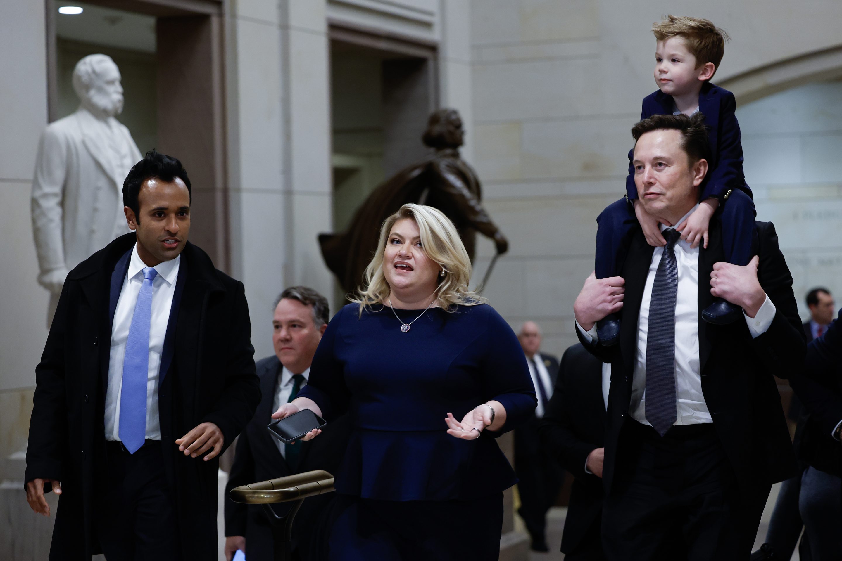 Vivek Ramaswamy (left) walks with Elon Musk and his son.