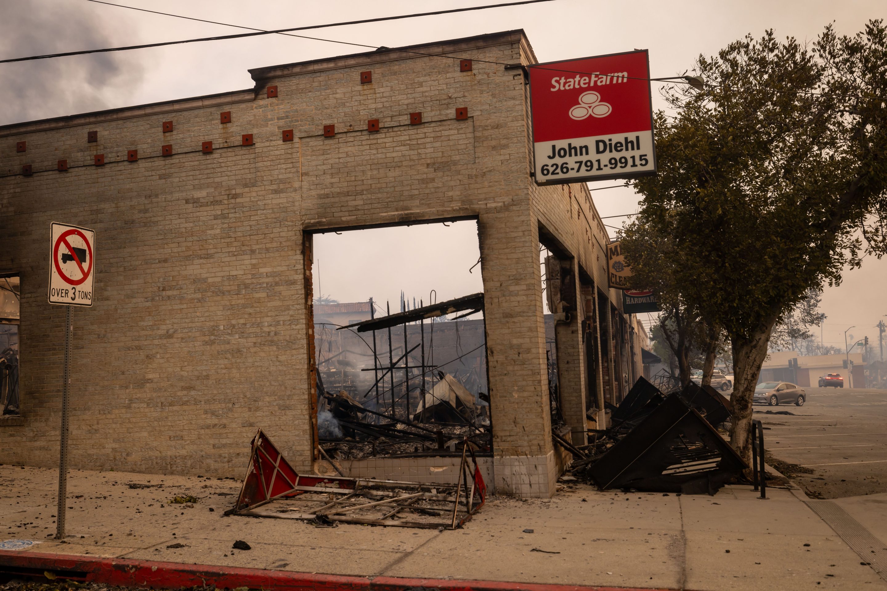 A State Farm Insurance sign on a destroyed building during the Eaton Fire in Altadena, California, US, on Wednesday, Jan. 8, 2025.