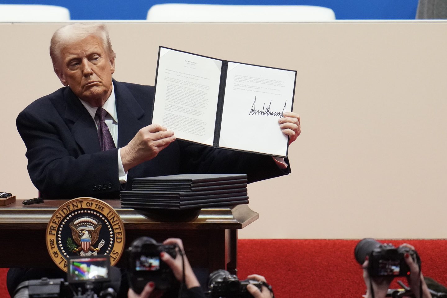 President Donald Trump holds up an executive order after signing it during his inauguration parade at Capital One Arena on January 20, 2025 in Washington, DC.