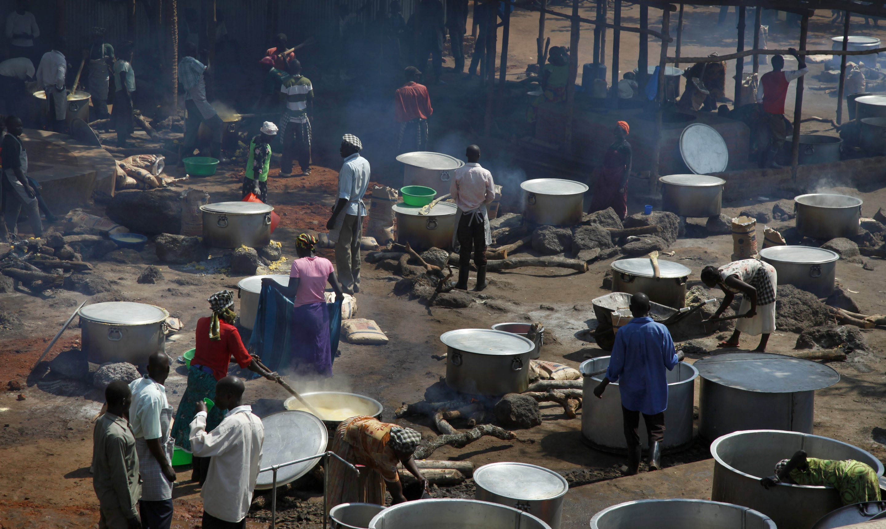 Refugees prepare food including maize porridge donated by USAID and known locally as posho, during the visit of U.N. in Adjumani, Uganda, Aug. 29, 2016.