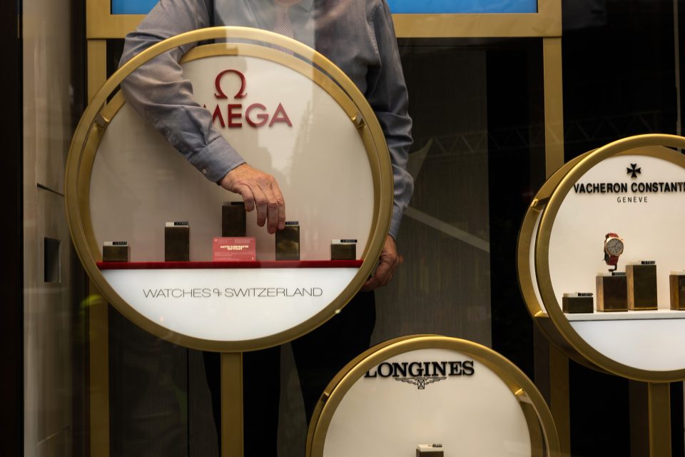 a man lining up watches on display