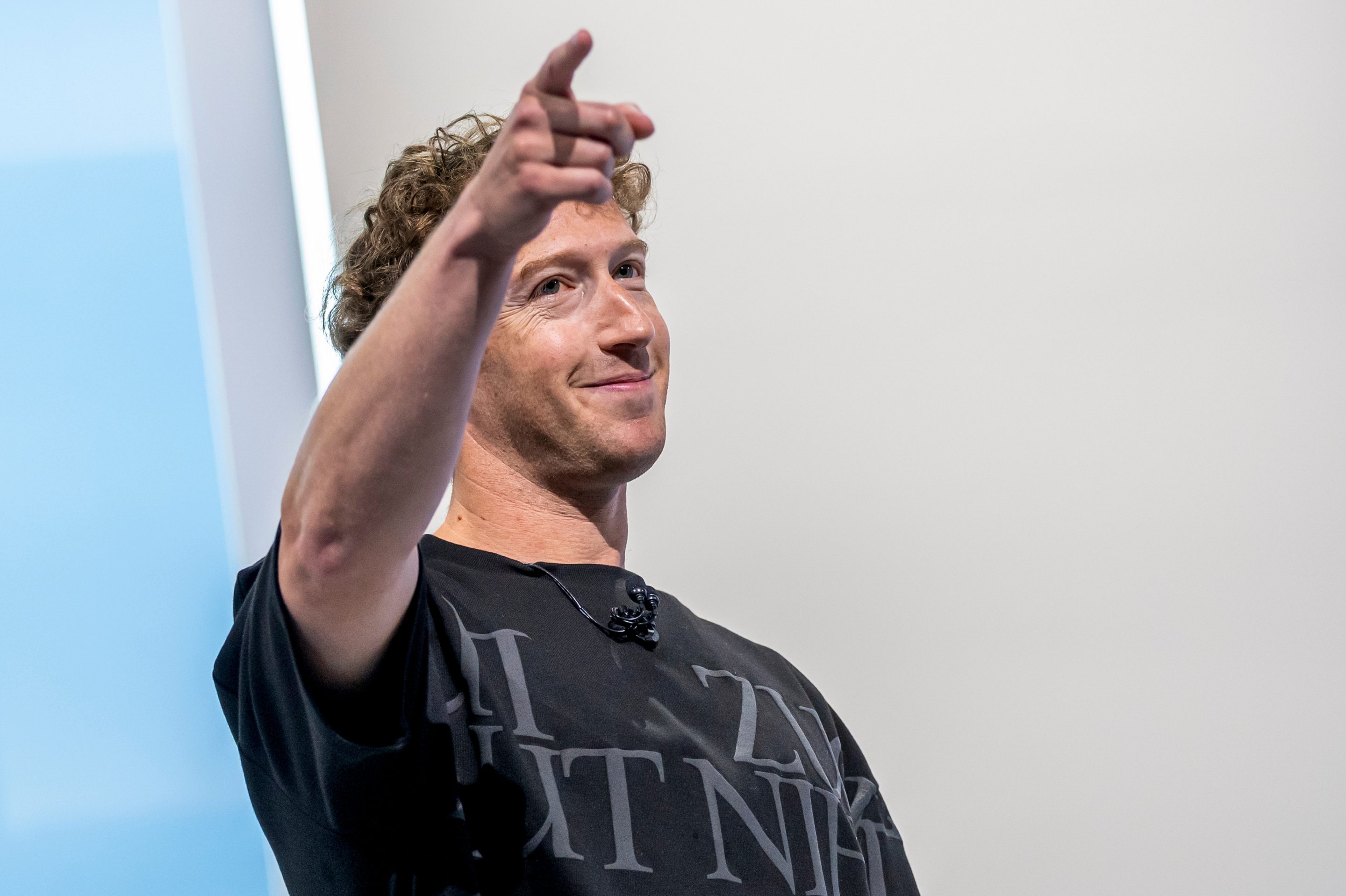 Mark Zuckerberg points into the crowd while on stage