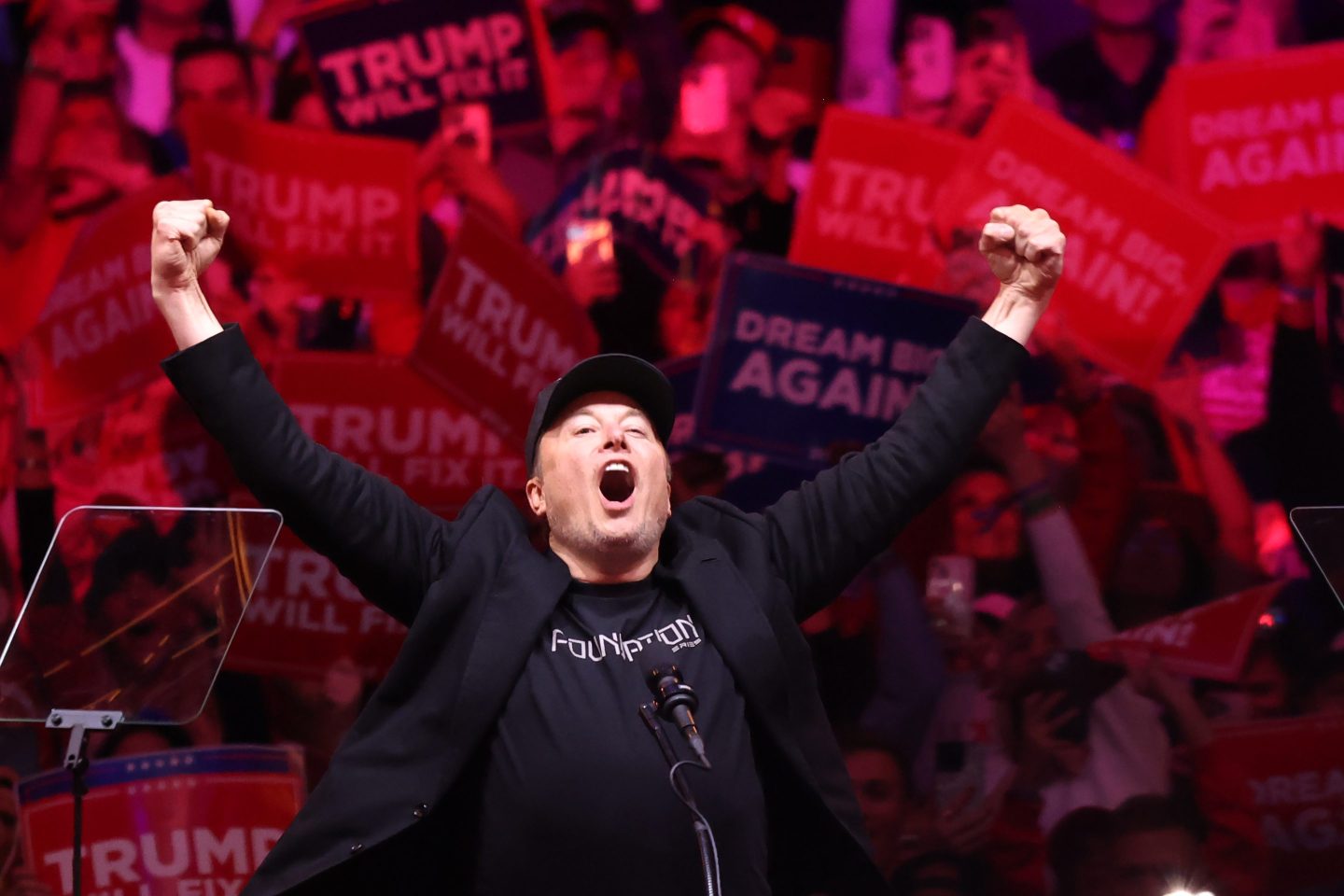 Elon Musk raises his arms in triumph