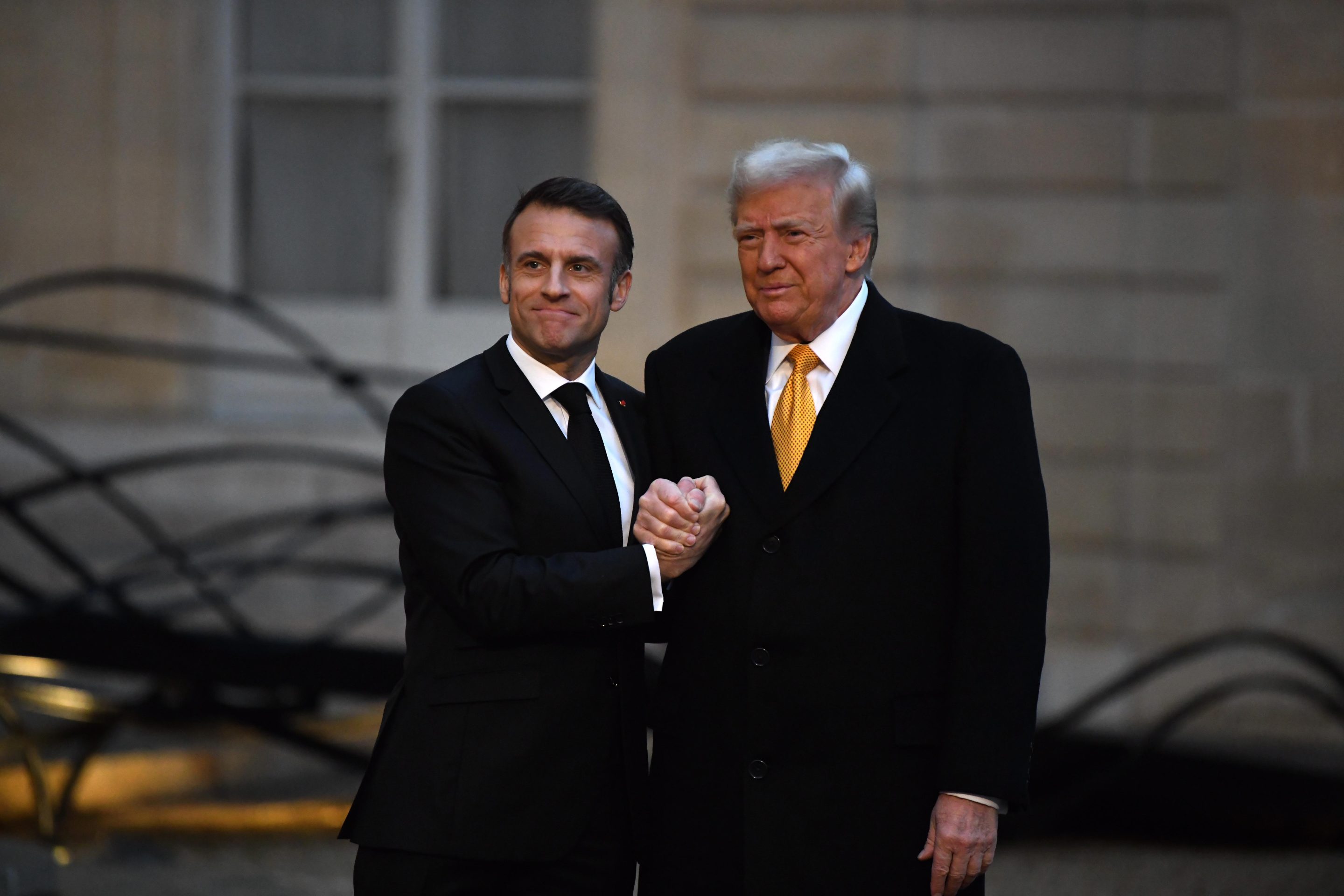 French President Emmanuel Macron shakes hands with U.S. President Donald Trump.
