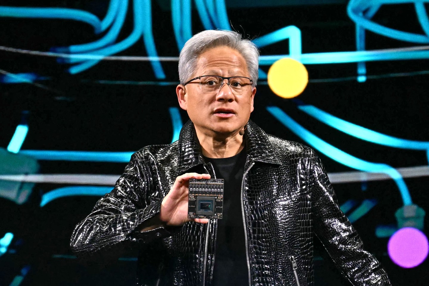 Nvidia CEO Jensen Huang holding an AI chip.
