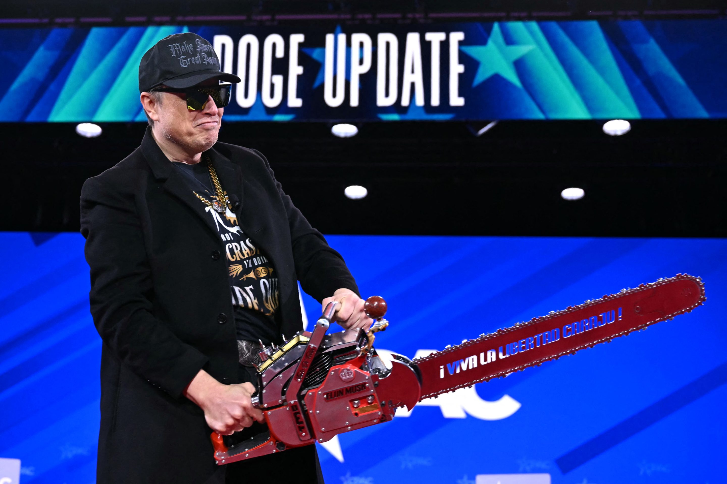 Elon Musk holds a chainsaw reading "Long live freedom, damn it" during the annual Conservative Political Action Conference (CPAC) on Feb. 20, 2025. 
