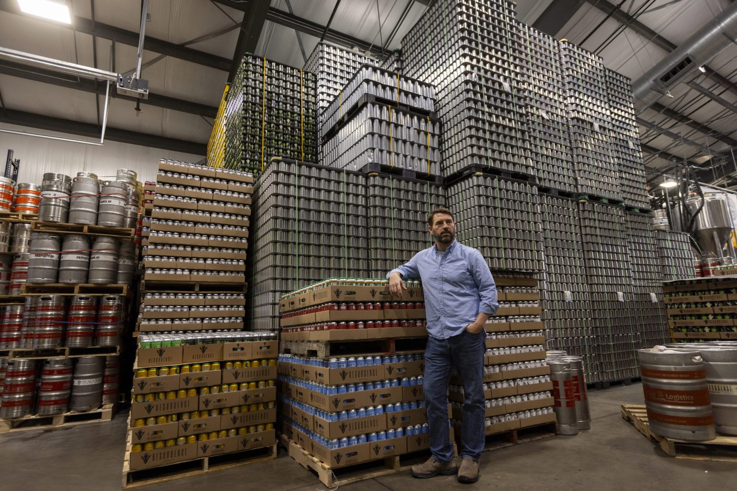 Jeff Ware, president of Resurgence Brewing Company, poses for a portrait near a stockpile of aluminum cans, which are sourced from Canada, Thursday, Feb. 27, 2025, in Buffalo, N.Y.