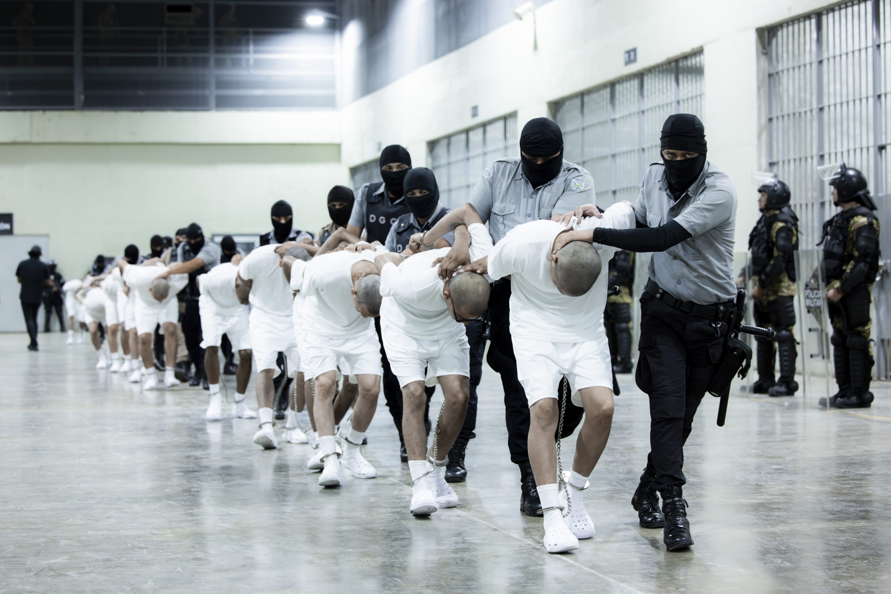 In this photo provided by El Salvador's presidential press office, prison guards transfer deportees from the U.S.
