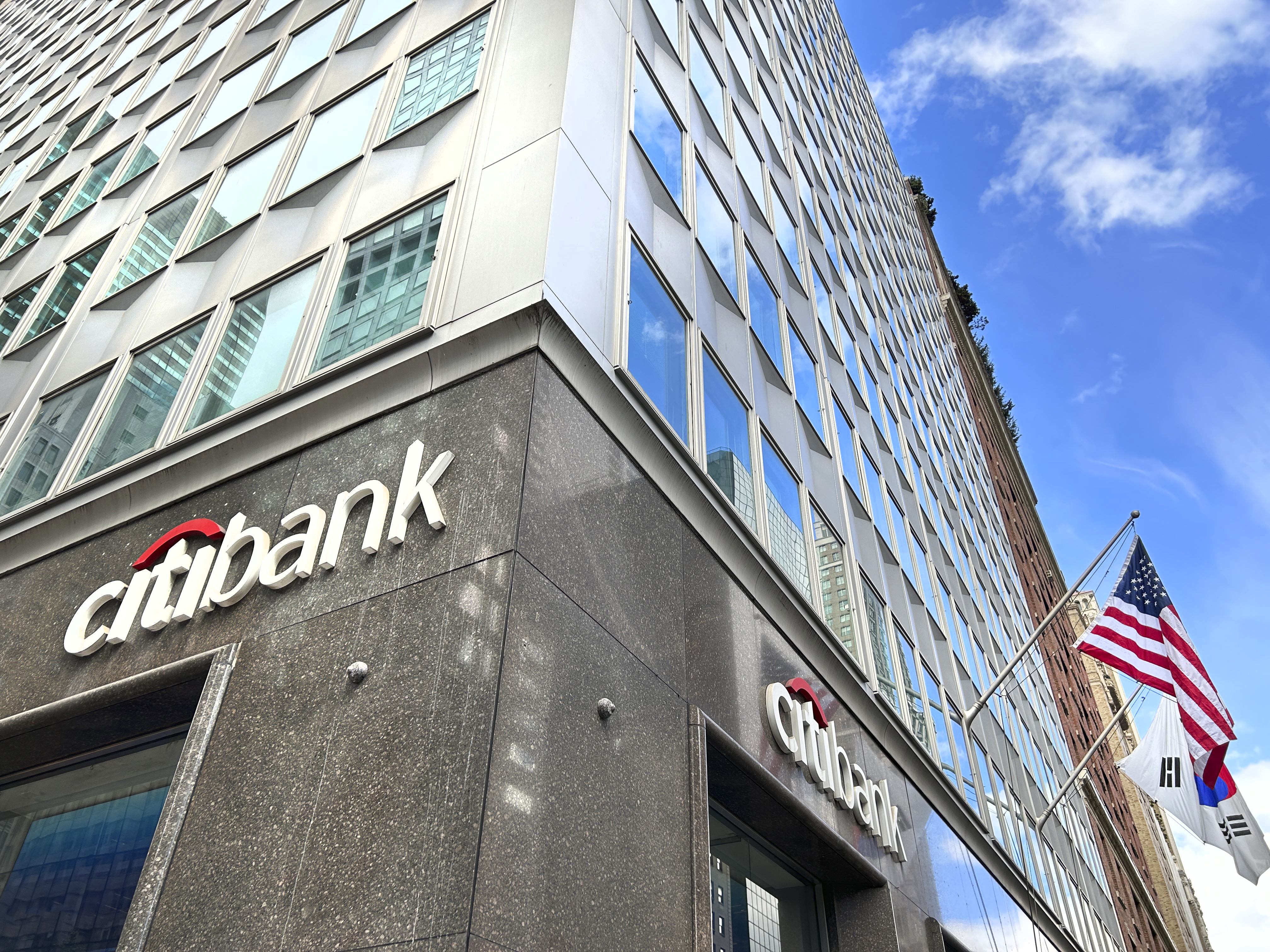 the outside of a Citibank at the bottom of a high rise building