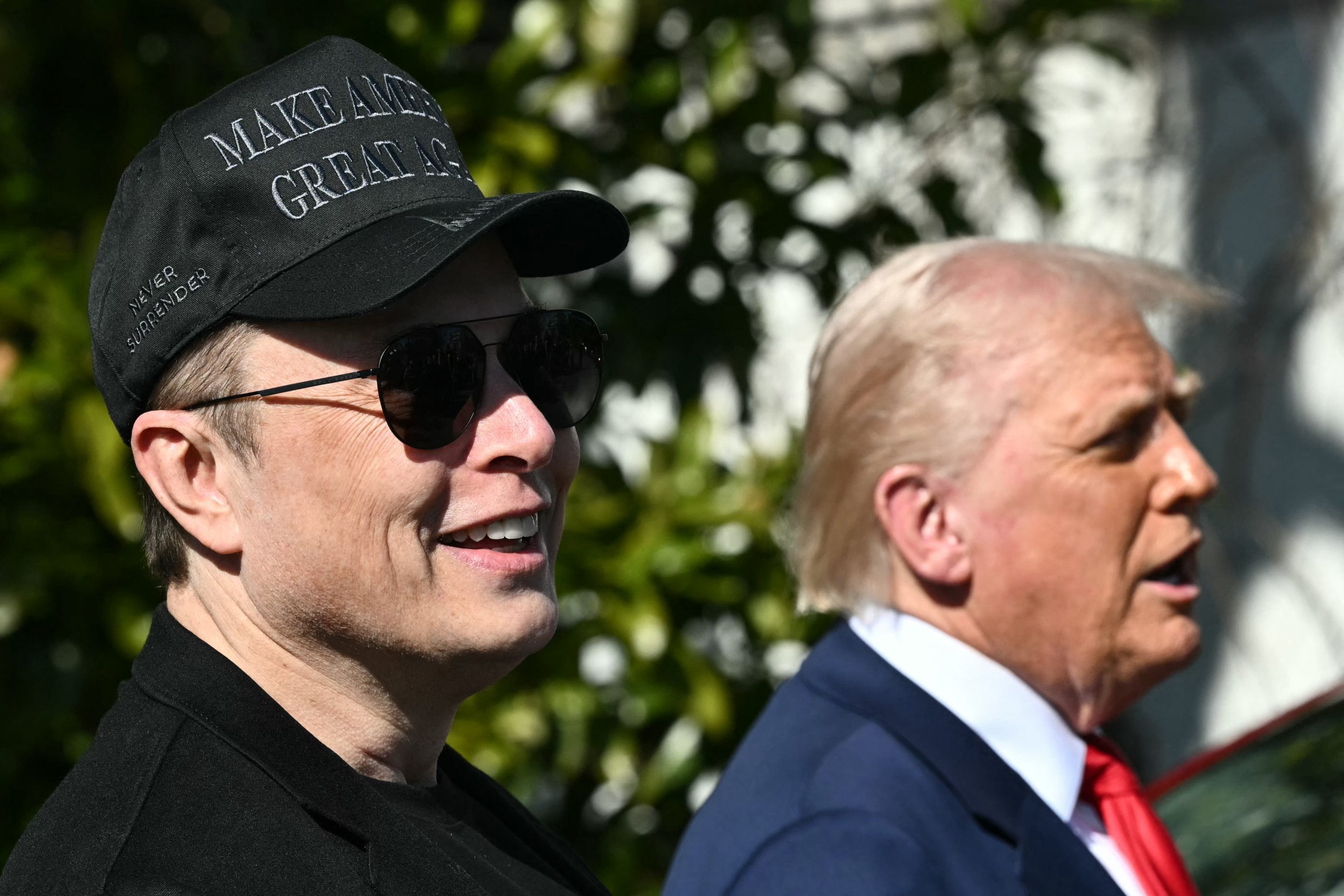 US President Donald Trump and Tesla CEO Elon Musk speak to the press as they stand next to a Tesla vehicle on the South Portico of the White House.