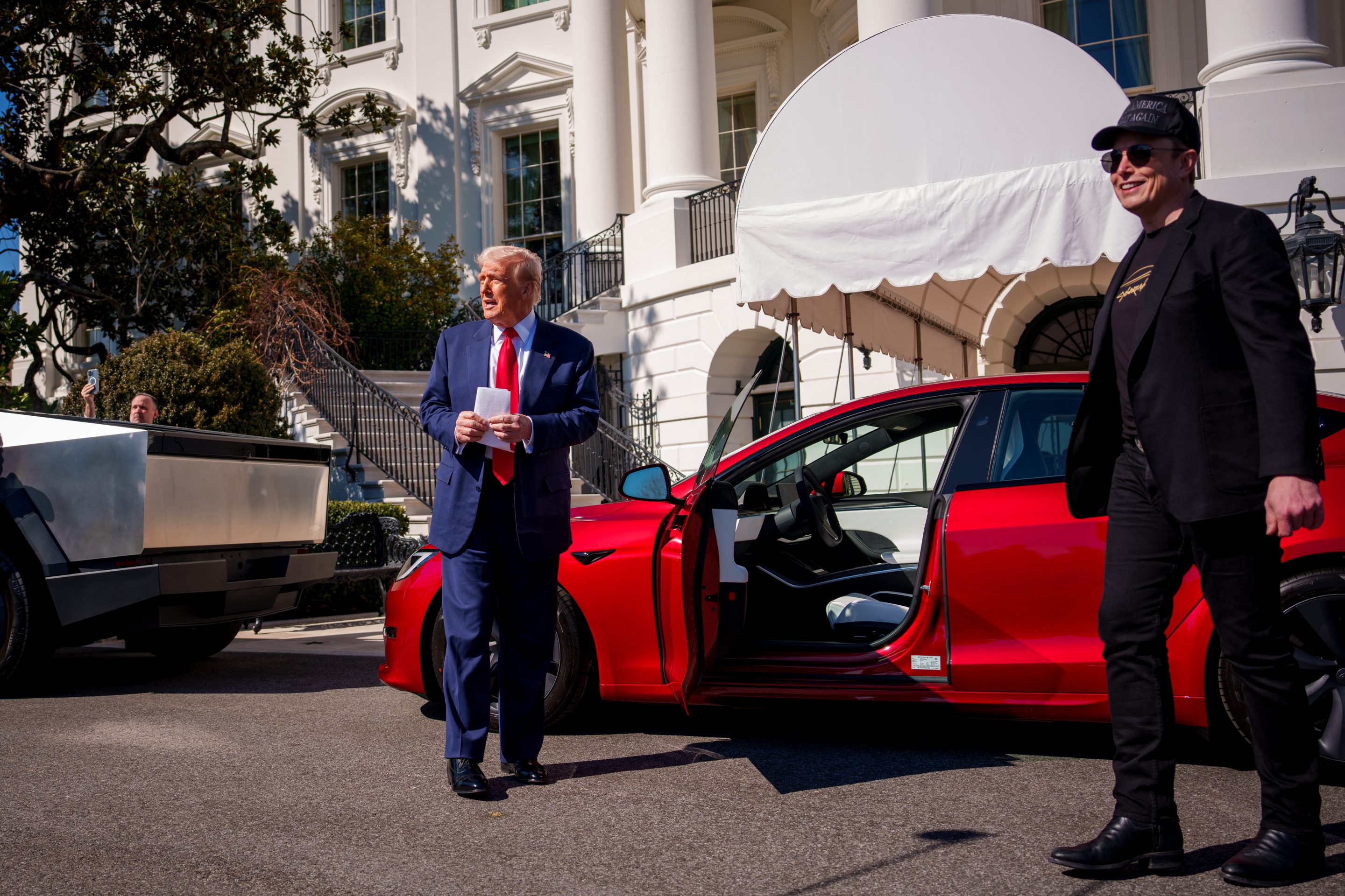 Tesla CEO Elon Musk (right) poses with President Donald Trump in front of a Tesla.