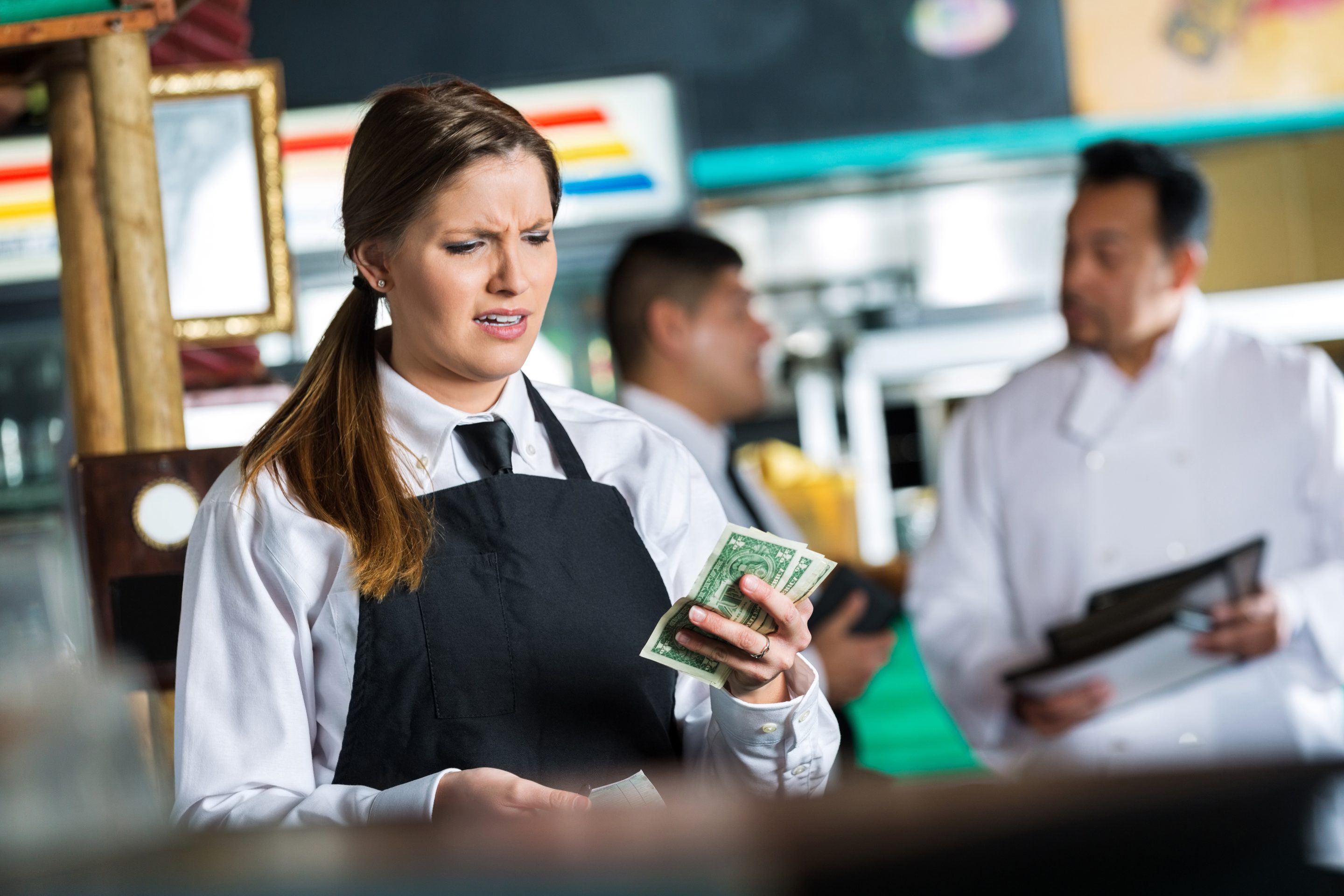 Woman disappointed holding just a few dollars.