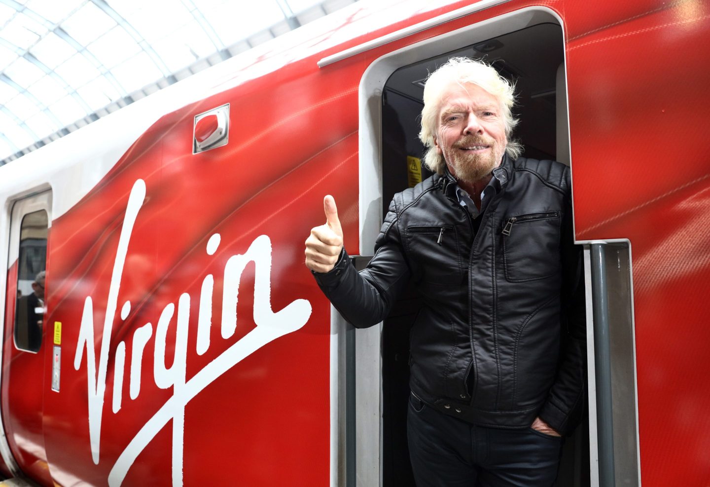 Richard Branson, chairman and founder of Virgin Group Ltd., poses for a photograph on board a new Virgin Azuma high speed train, manufactured by Hitachi Ltd., at Kings Cross station, London, U.K., on Friday, March 18, 2016. Virgin Trains will revive plans to offer high-speed Internet access on Europes busiest rail route in a bid to beat the plane and persuade business people to travel outside peak hours.