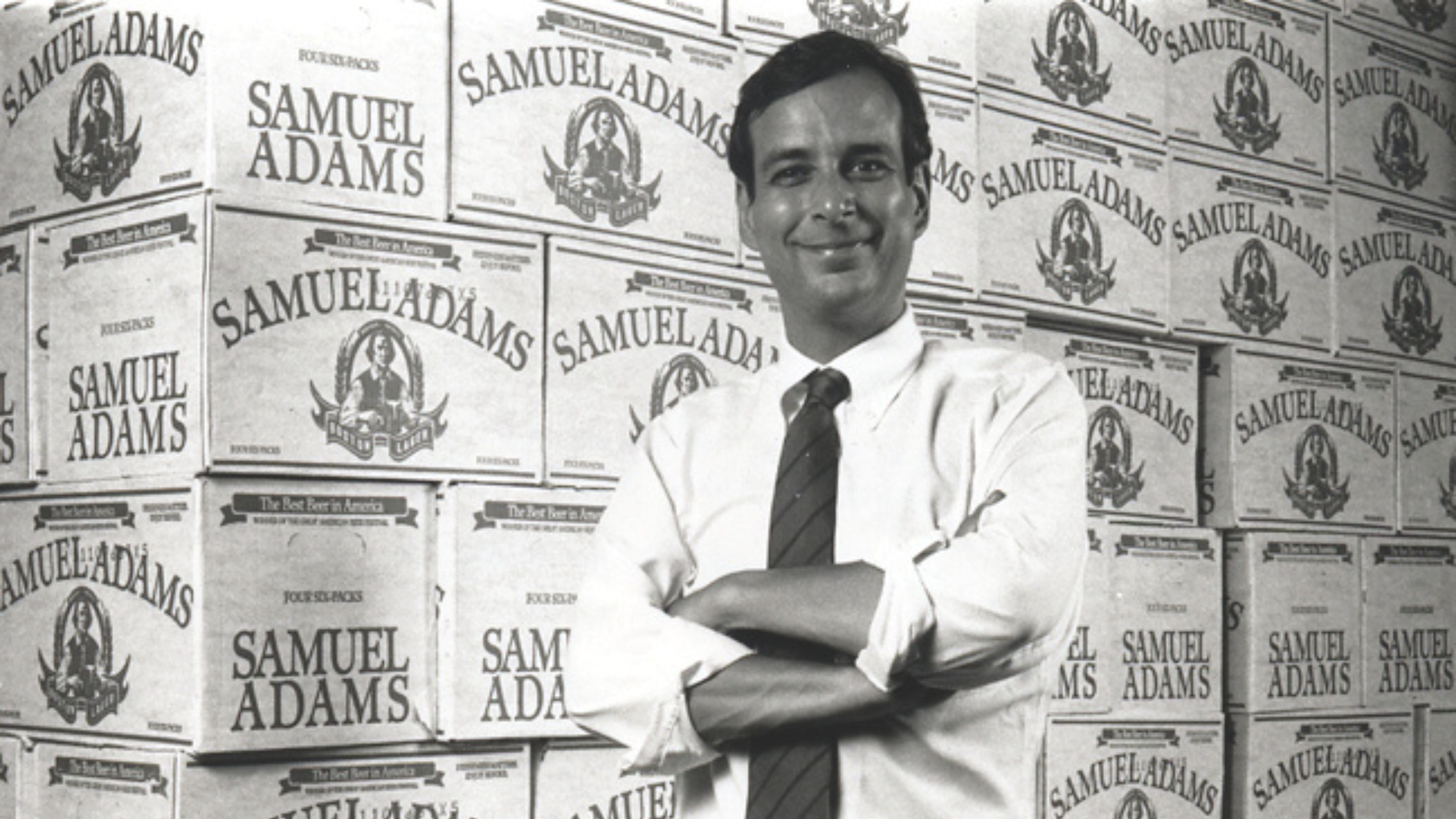 Founder Jim Koch poses by cases of Samuel Adams.