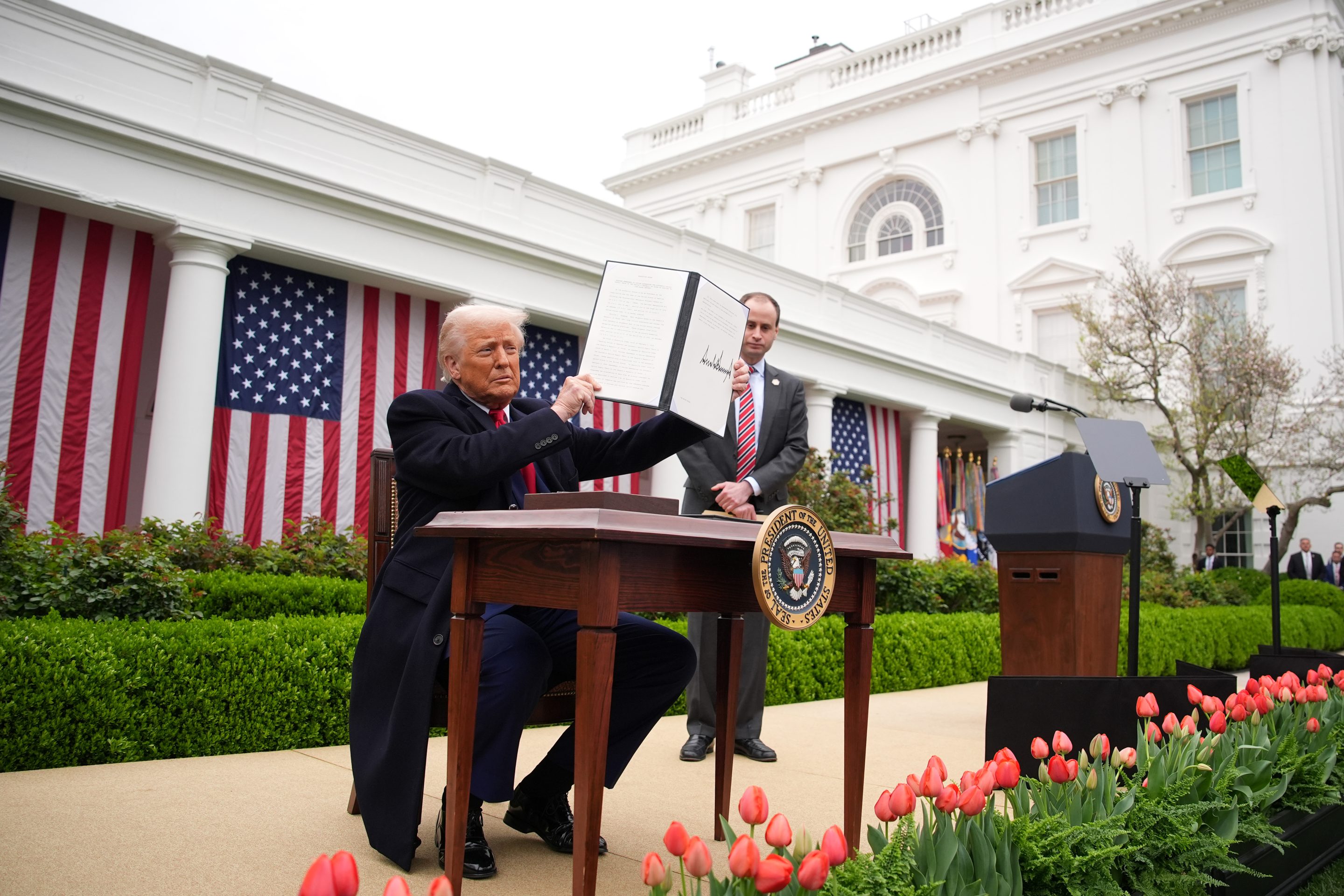 President Donald Trump displaying a signed executive order imposing sweeping tariffs on imported goods this week.