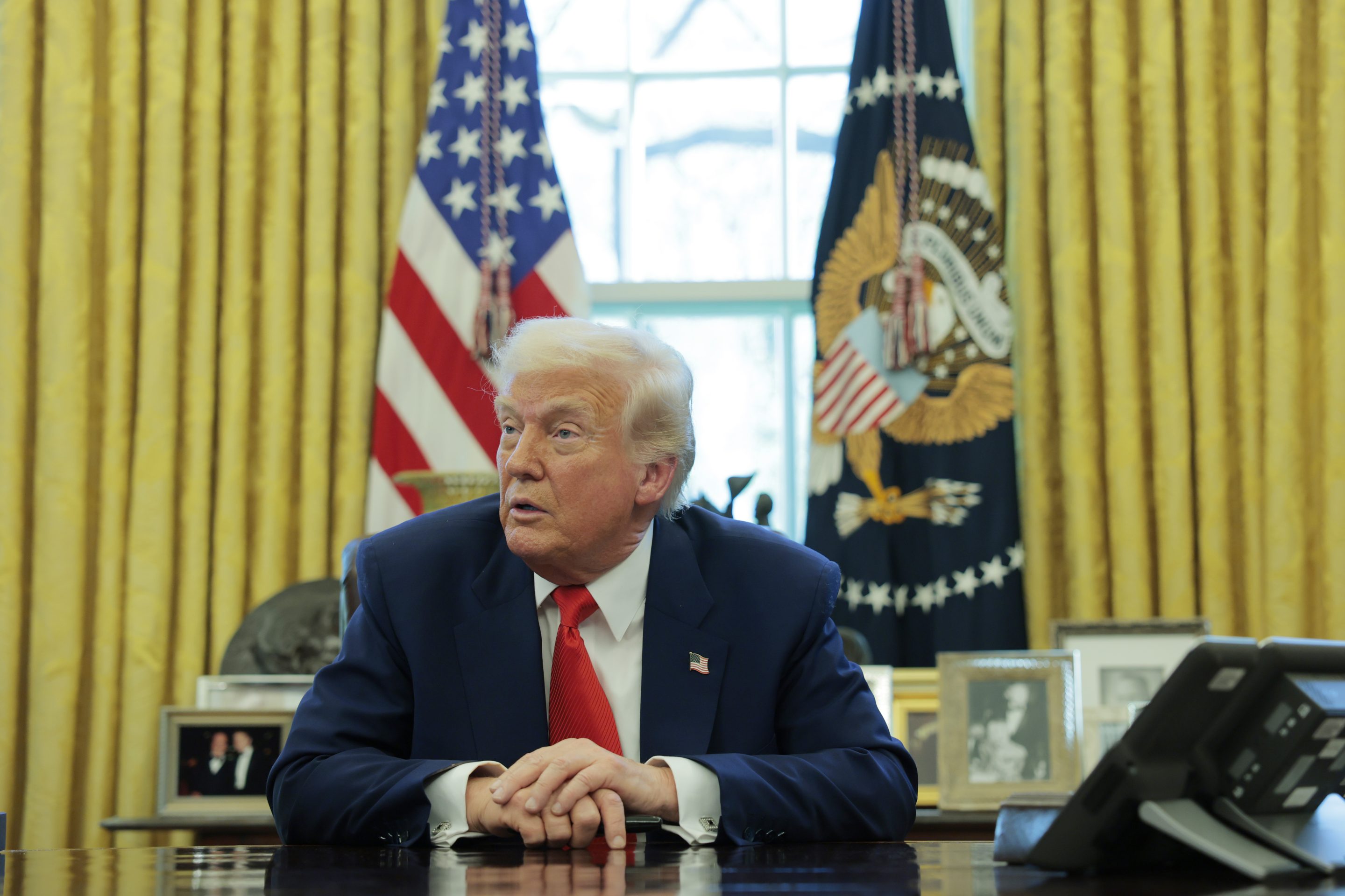President Donald Trump speaks to reporters while in the Oval Office