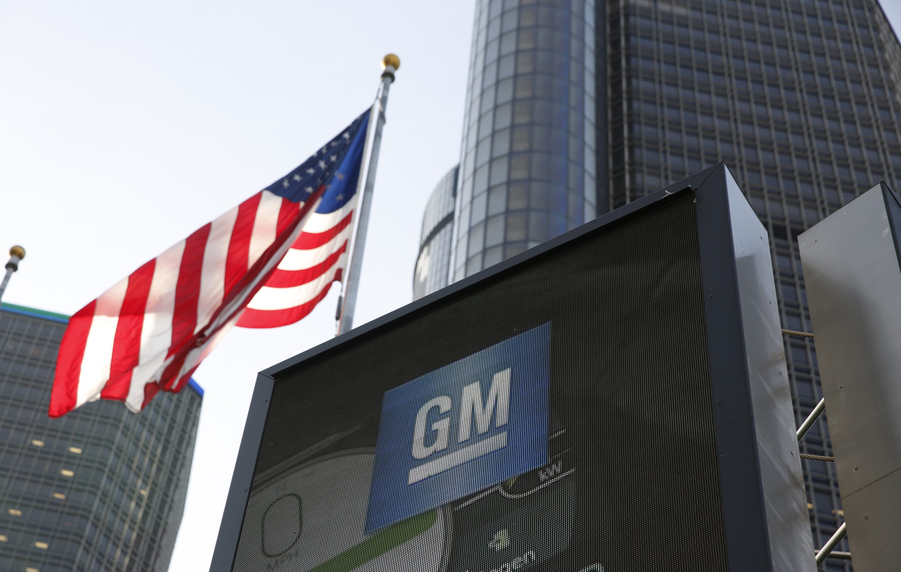 American flag billows next to a GM sign