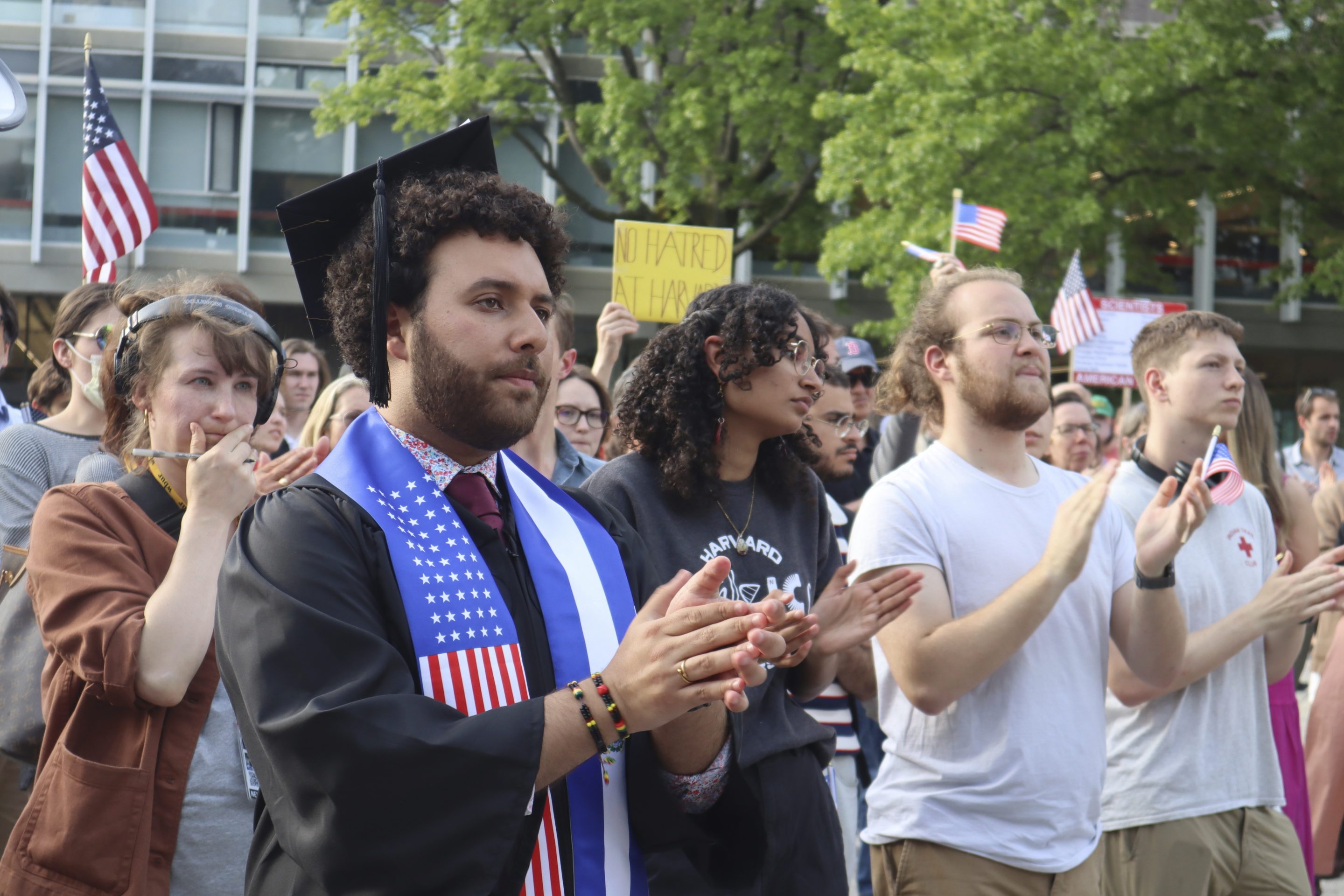 Harvard University graduating senior Victor Flores claps while listening to a fellow student speak at a protest against President Donald Trump's recent sanctions against Harvard in front of Science Center Plaza on Tuesday, May 27, 2025, in Cambridge, Mass.