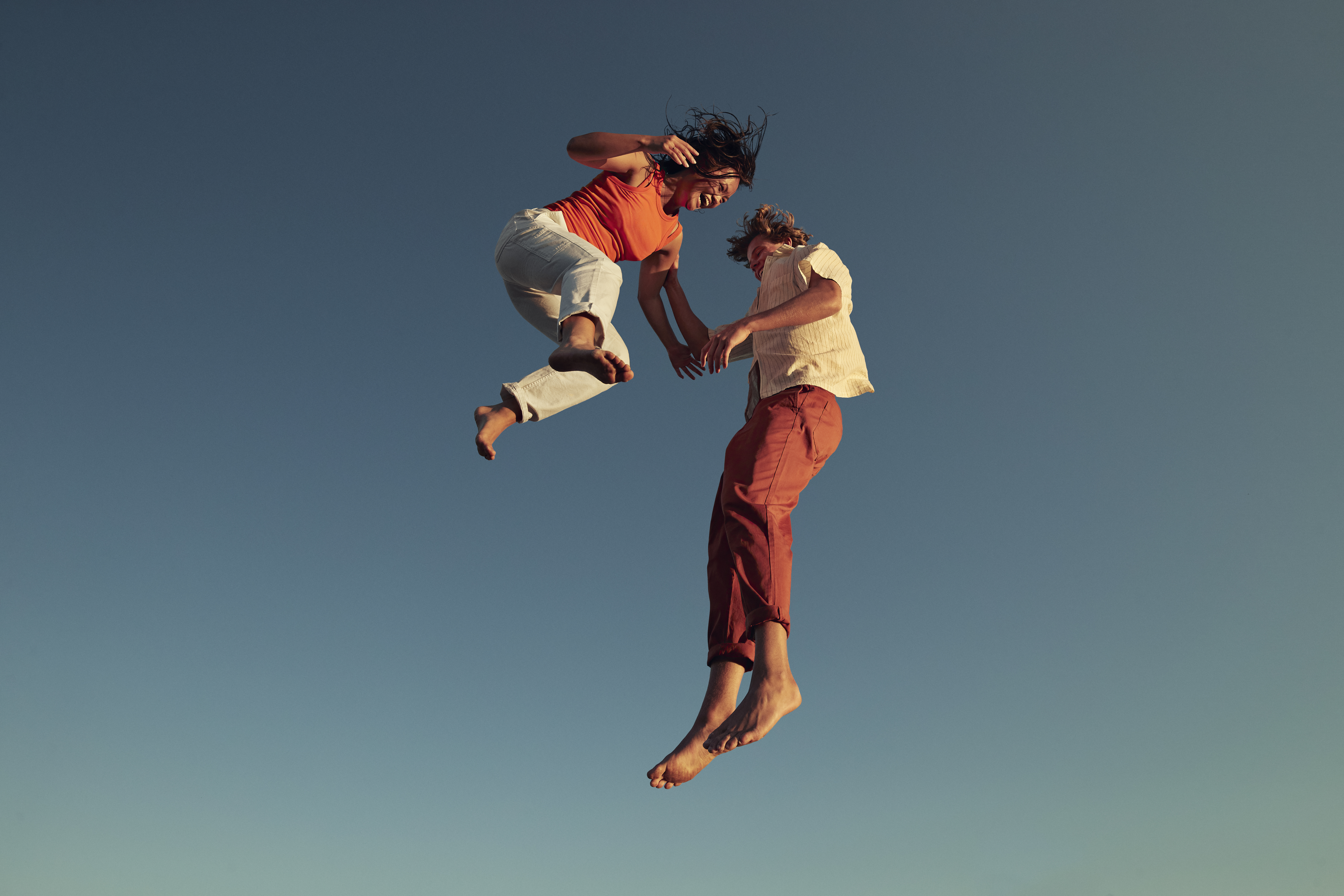 Photo shows two people jumping for joy.