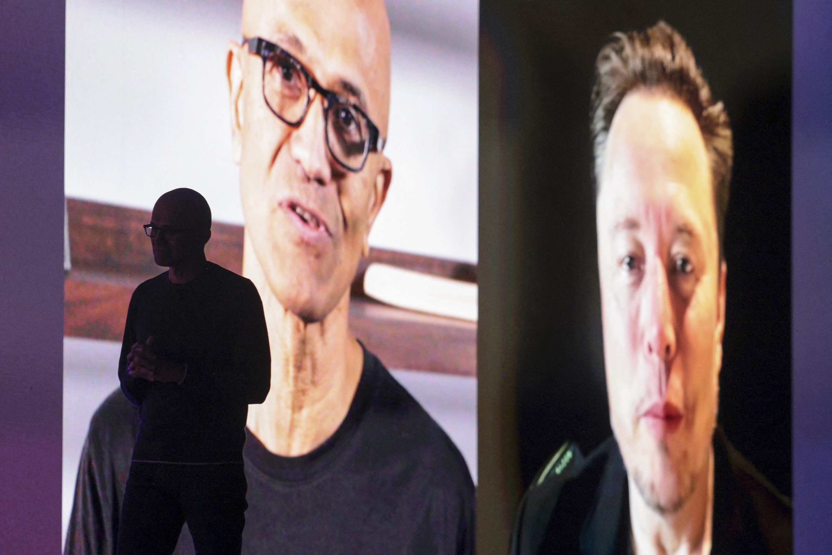 Microsoft Chairman and Chief Executive Officer Satya Nadella is silhouetted as a pre-recorded interview with Elon Musk