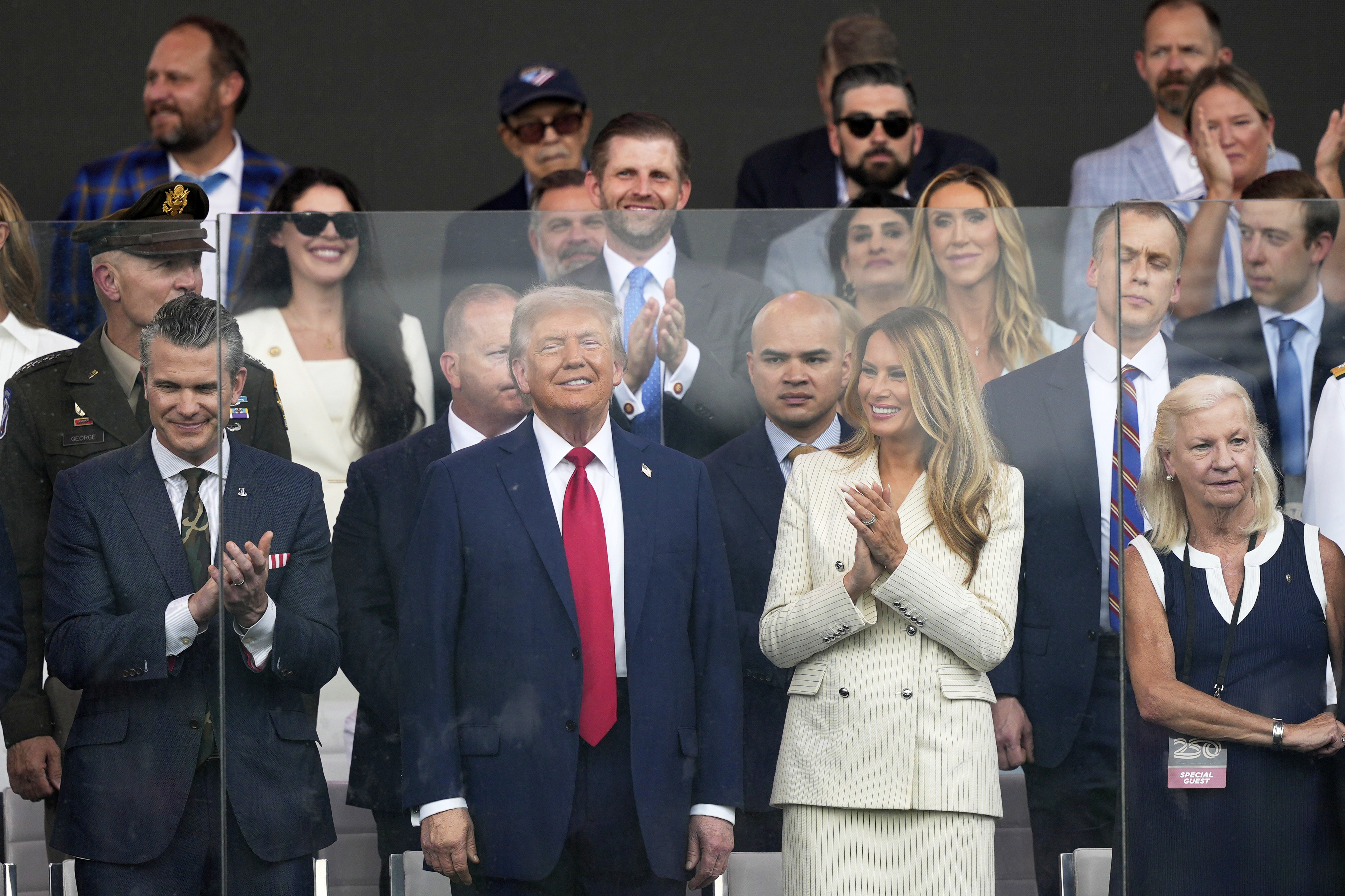 President Donald Trump, first lady Melania Trump, and Defense Secretary Pete Hegseth, left, attend a military parade commemorating the Army's 250th anniversary, coinciding with his 79th birthday, on Saturday.