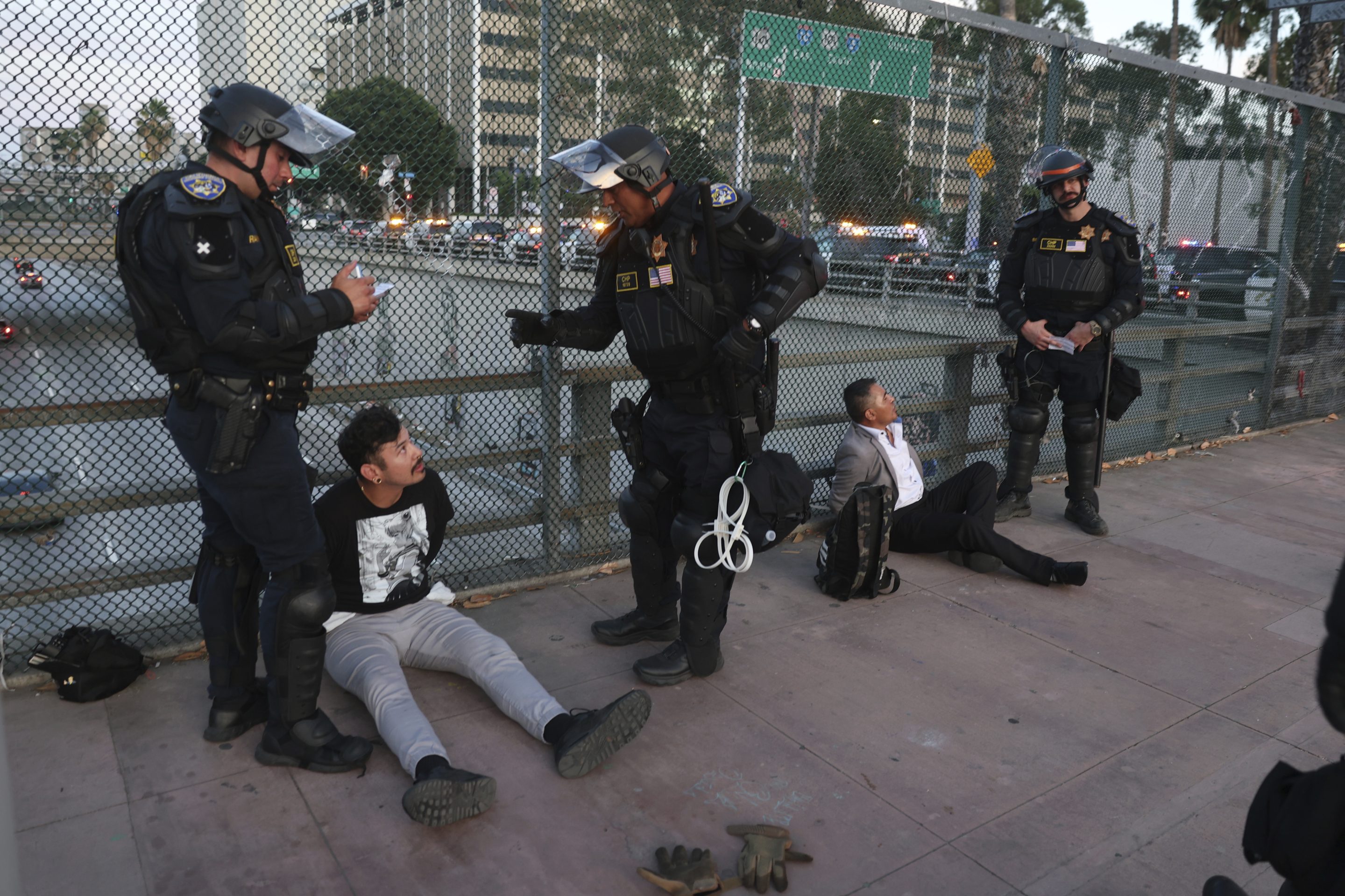 California Highway Patrol officers arrest two men after a dispersal order during a protest on June 14, 2025, in Los Angeles.