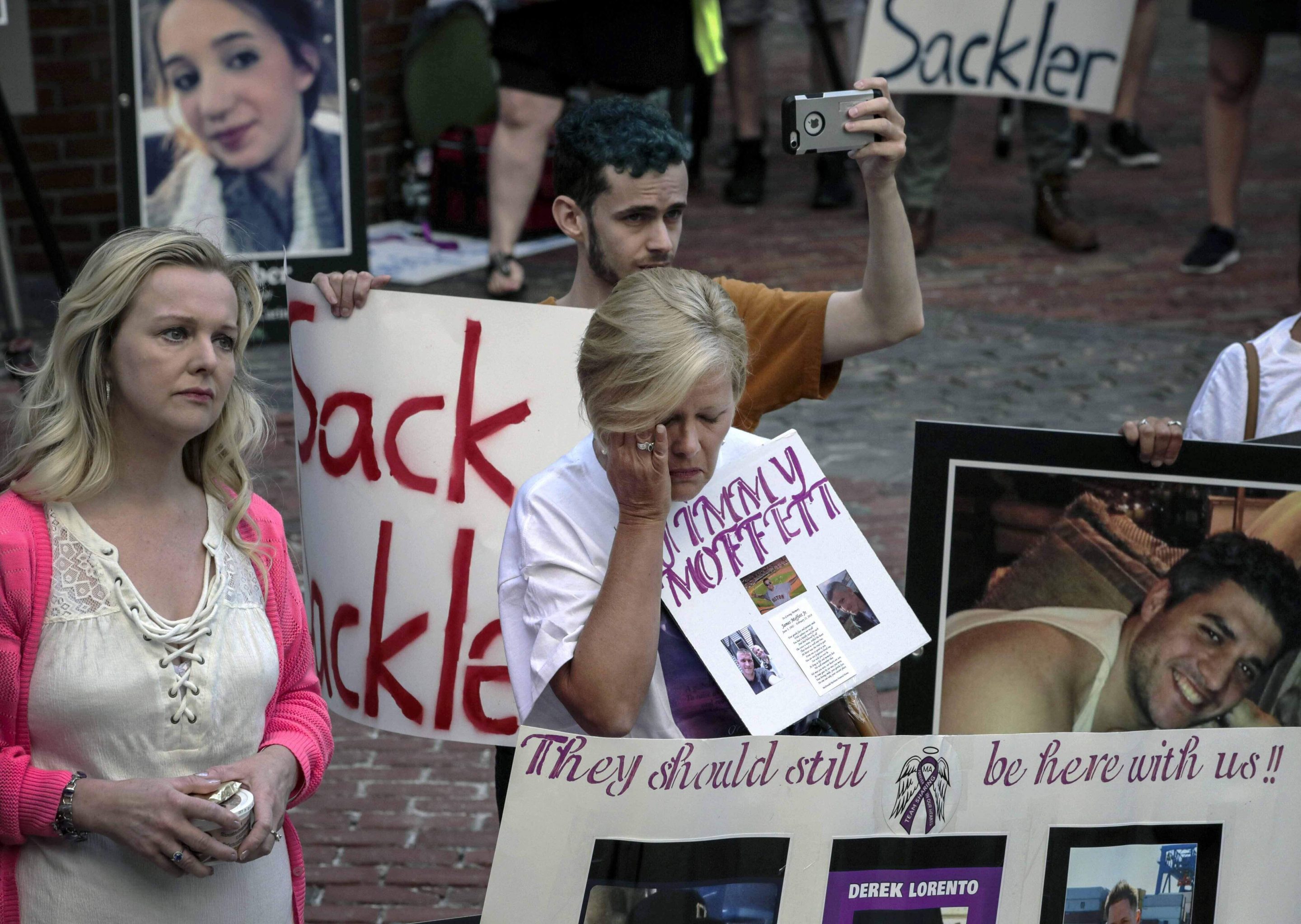 Protesters who have lost love ones to the opioid crisis protest outside a courthouse in Boston, Aug. 2, 2019, where a judge heard arguments in a lawsuit against Purdue Pharma.