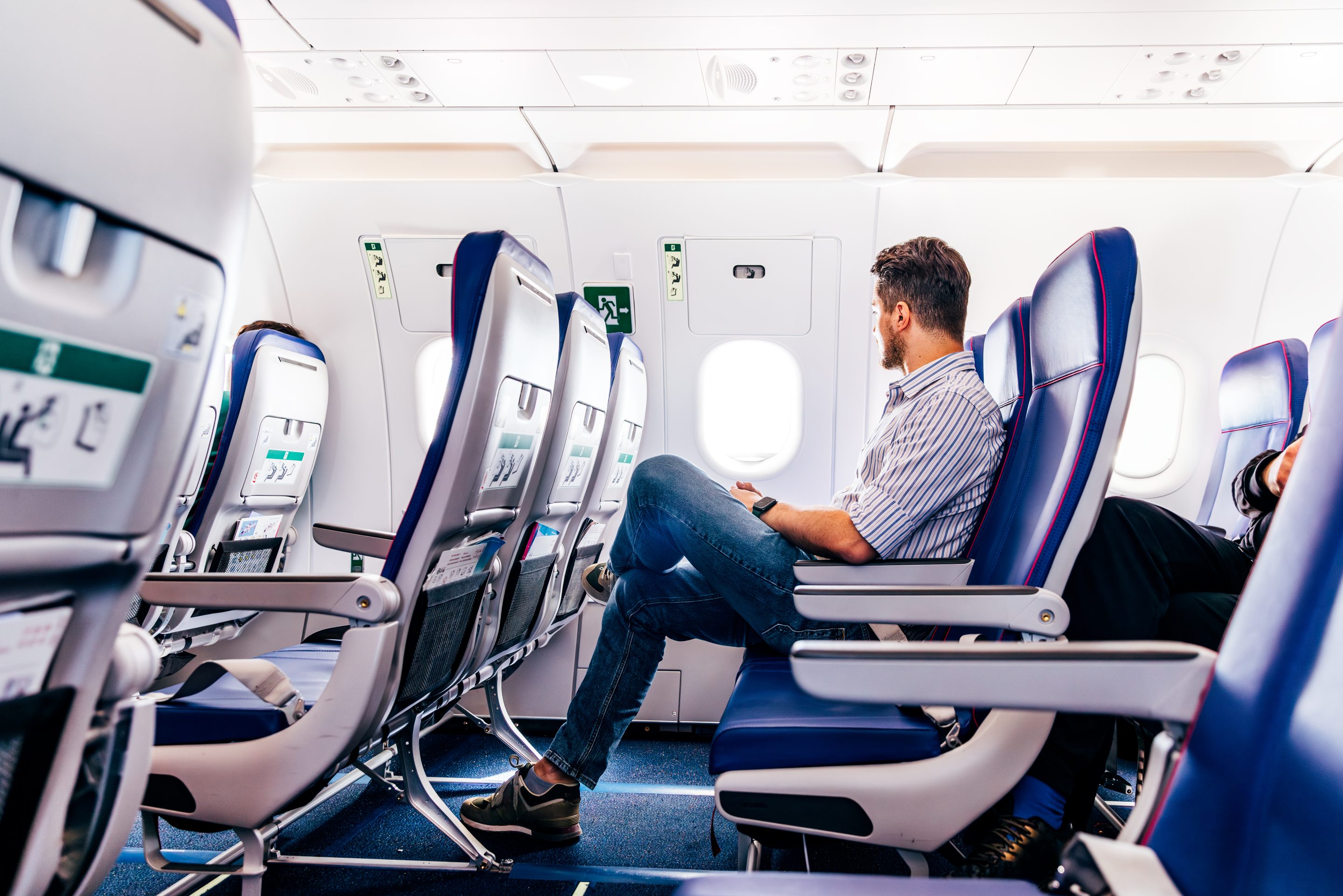 man looking out window on plane