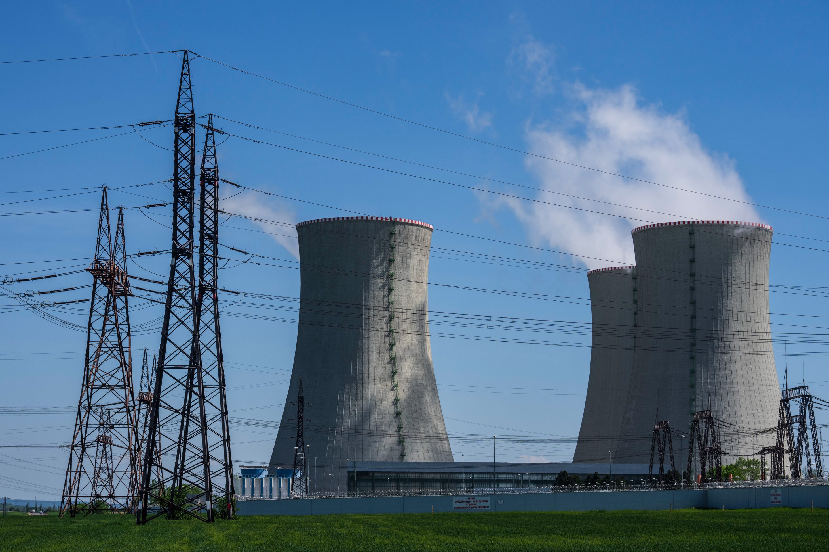 Image of cooling towers of a nuclear power plant and electric transmission lines.
