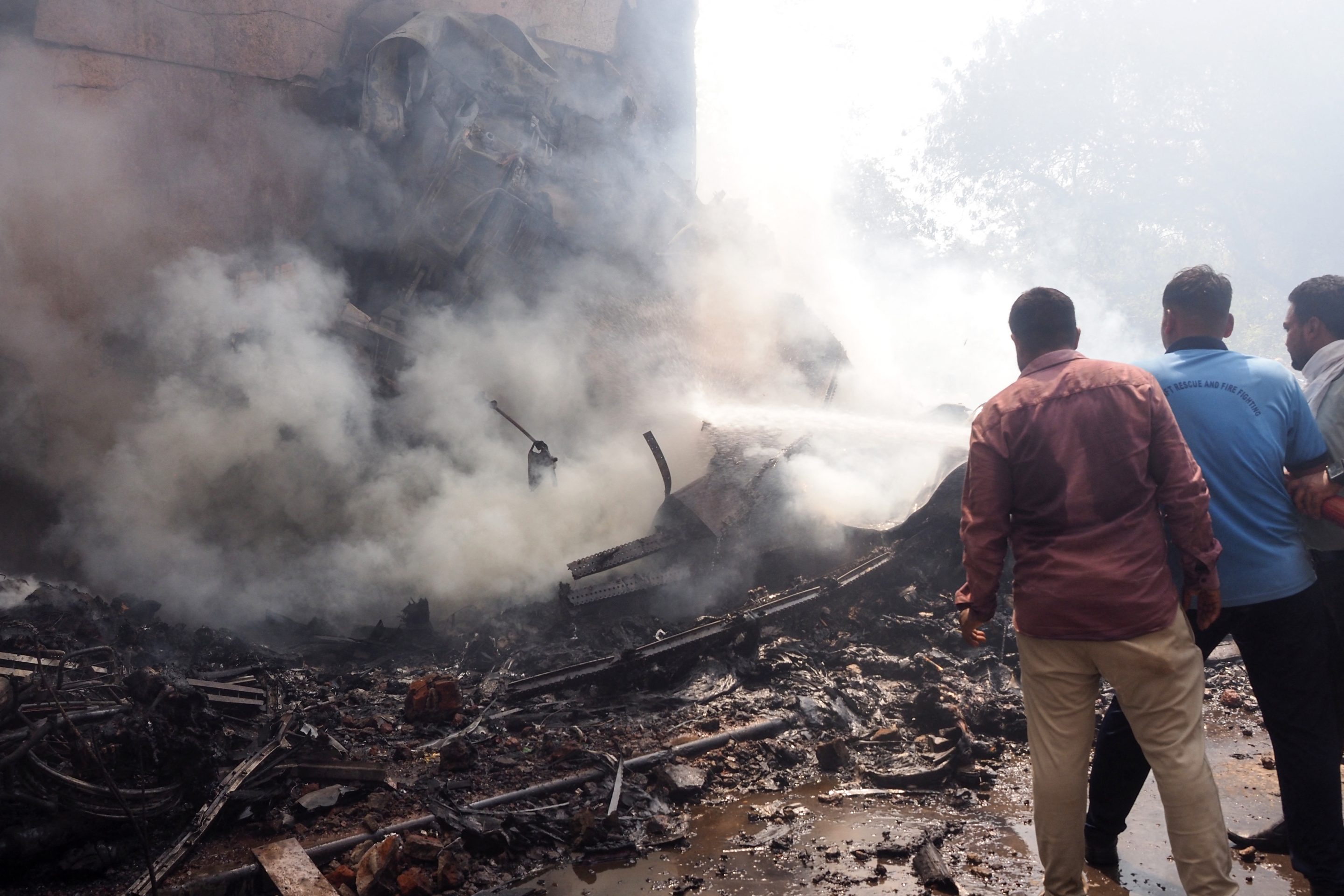 Firefighters work at the site where Air India flight 171 crashed in a residential area near the airport in Ahmedabad on June 12, 2025. 