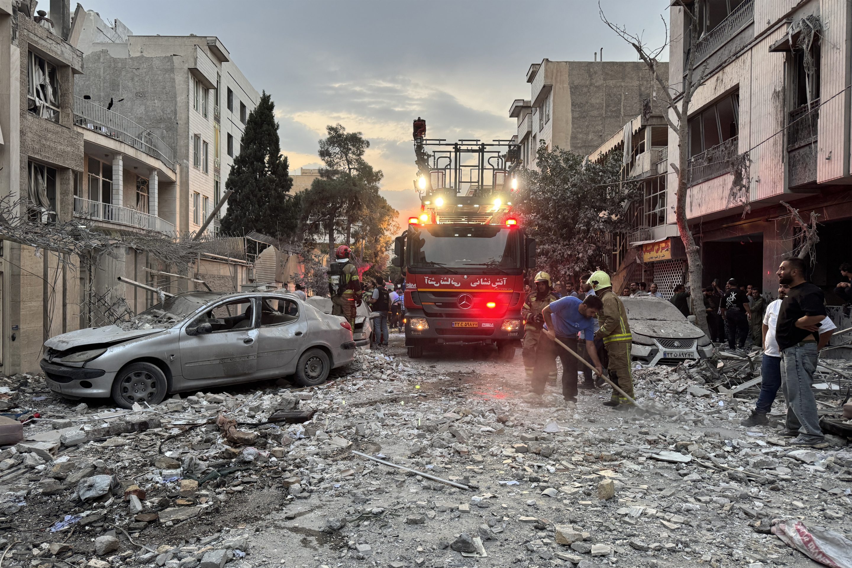 First responders gather outside a building hit by an Israeli strike in Tehran on Friday.
