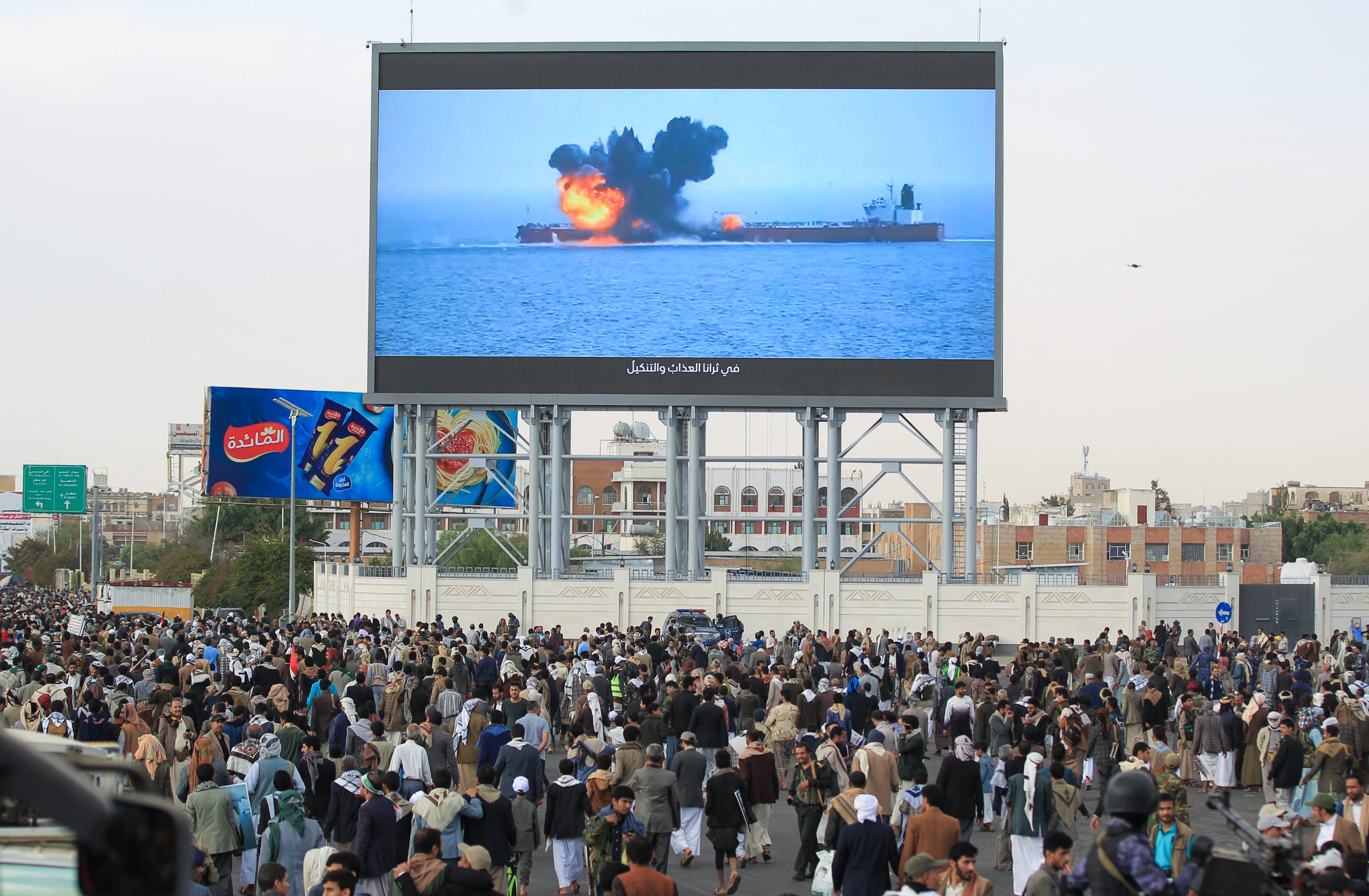 Images of a fireball exploding on a cargo ship are shown on a giant screen during a protest called for by Yemen's rebel Huthi movement in Sanaa on March 17, 2025.