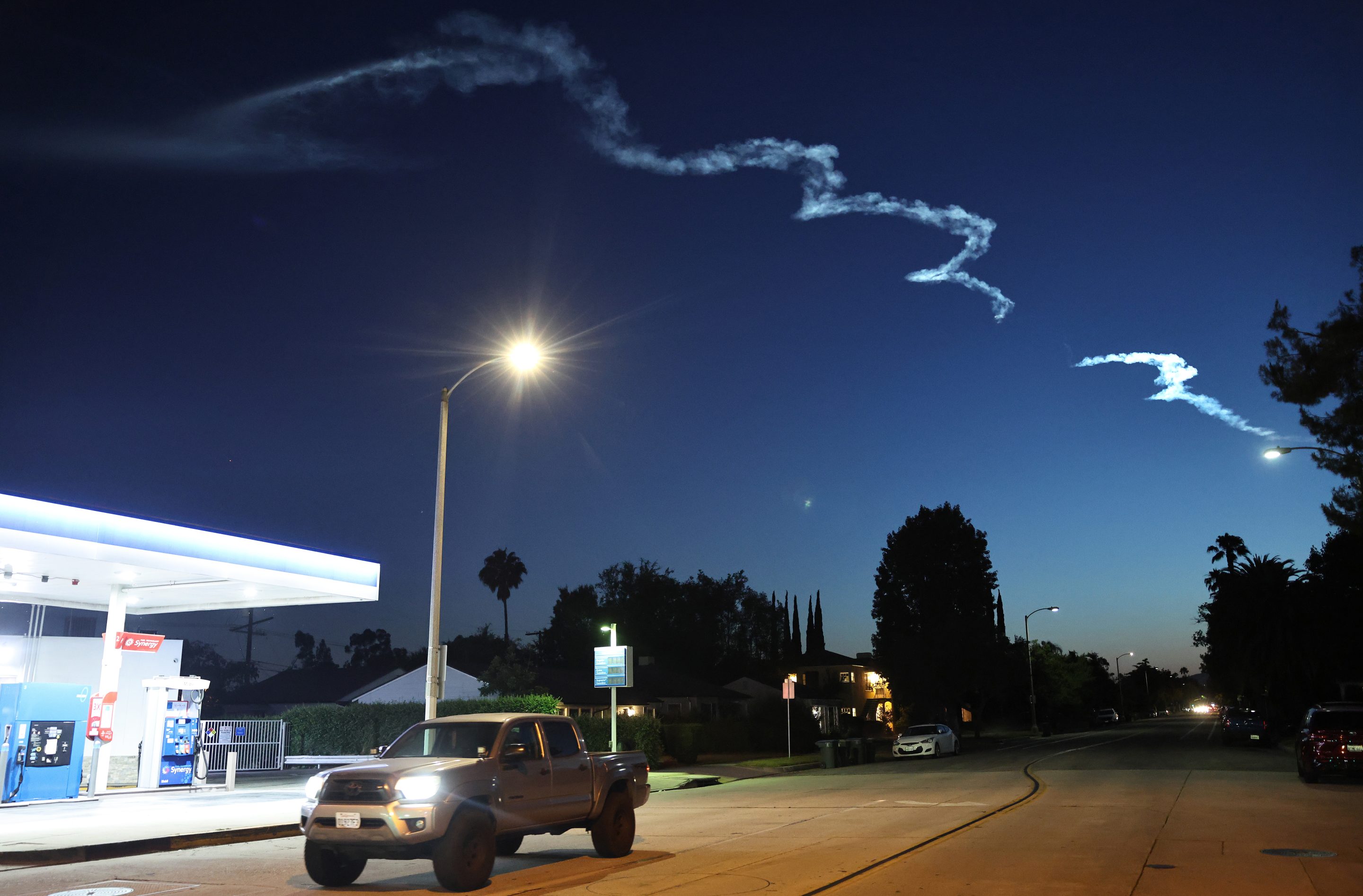 A vehicle passes below the contrail remaining from a SpaceX Falcon 9 rocket after launching from Vandenberg Space Force Base carrying 26 Starlink internet satellites on June 16, 2025 as seen from Pasadena, Calif.