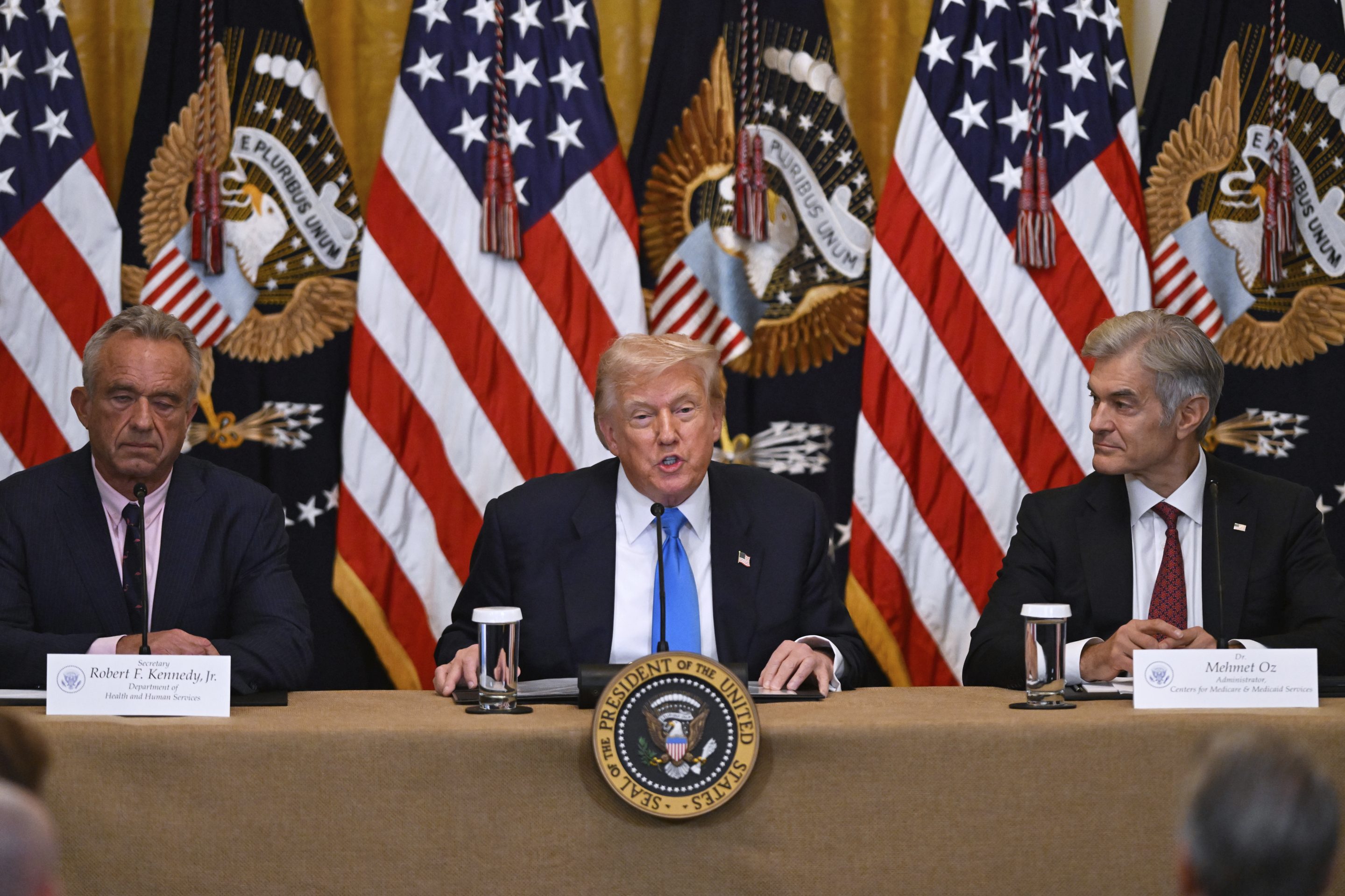 President Donald Trump at a White House event on July 30 with Health and Human Service Secretary Robert F. Kennedy, Jr., left, and Administrator of the Centers for Medicare and Medicaid Services, Mehmet Oz, right.