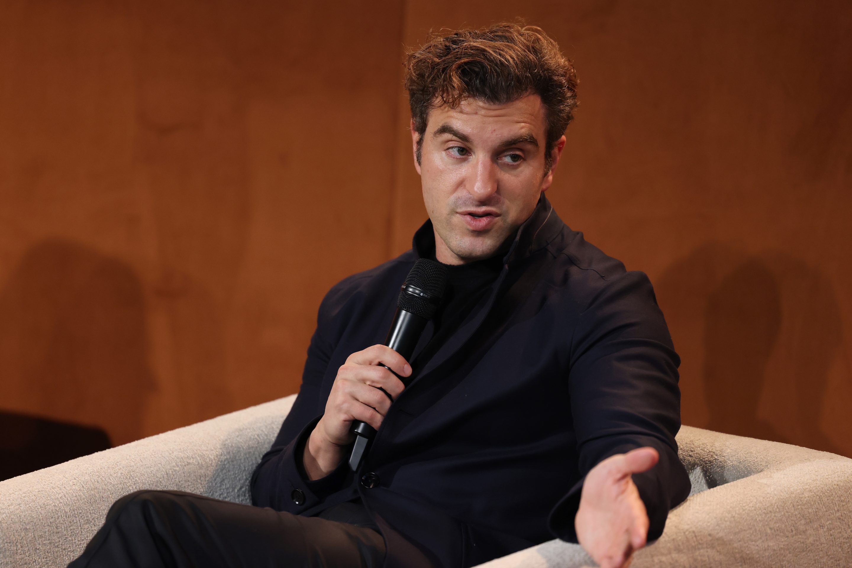 Brian Chesky speaks into a mic