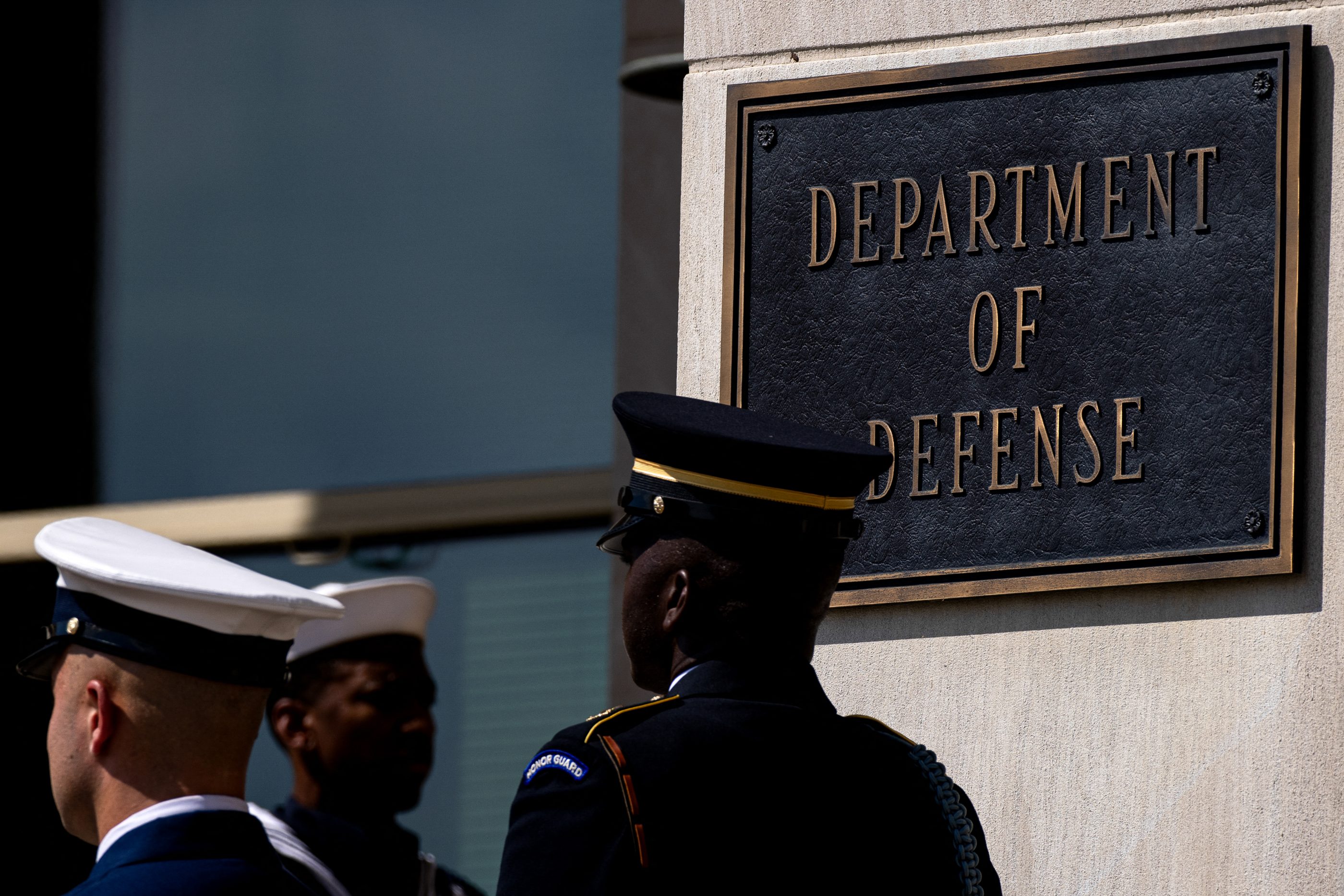 Soliders walk by the US D.O.D sign.
