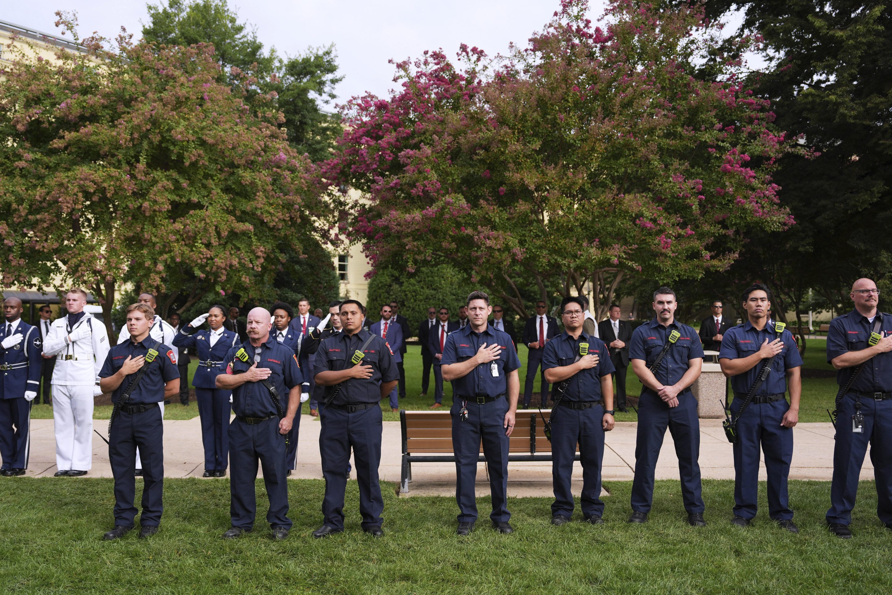 Armed Forces and first responders stand in a formation and have their hands over their hearts in remembrance of the 9/11 attacks.