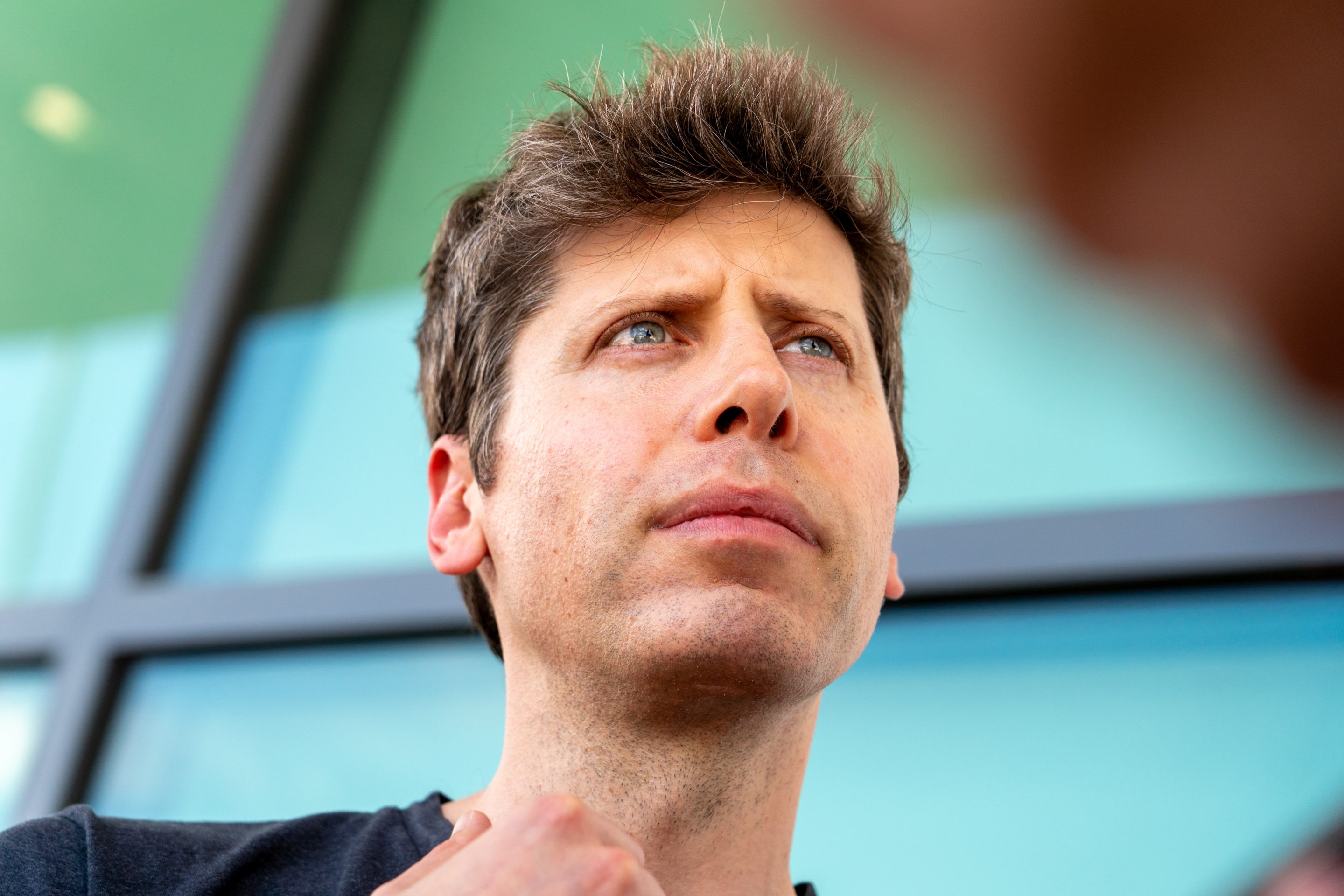 Sam Altman with a colorful window behind him