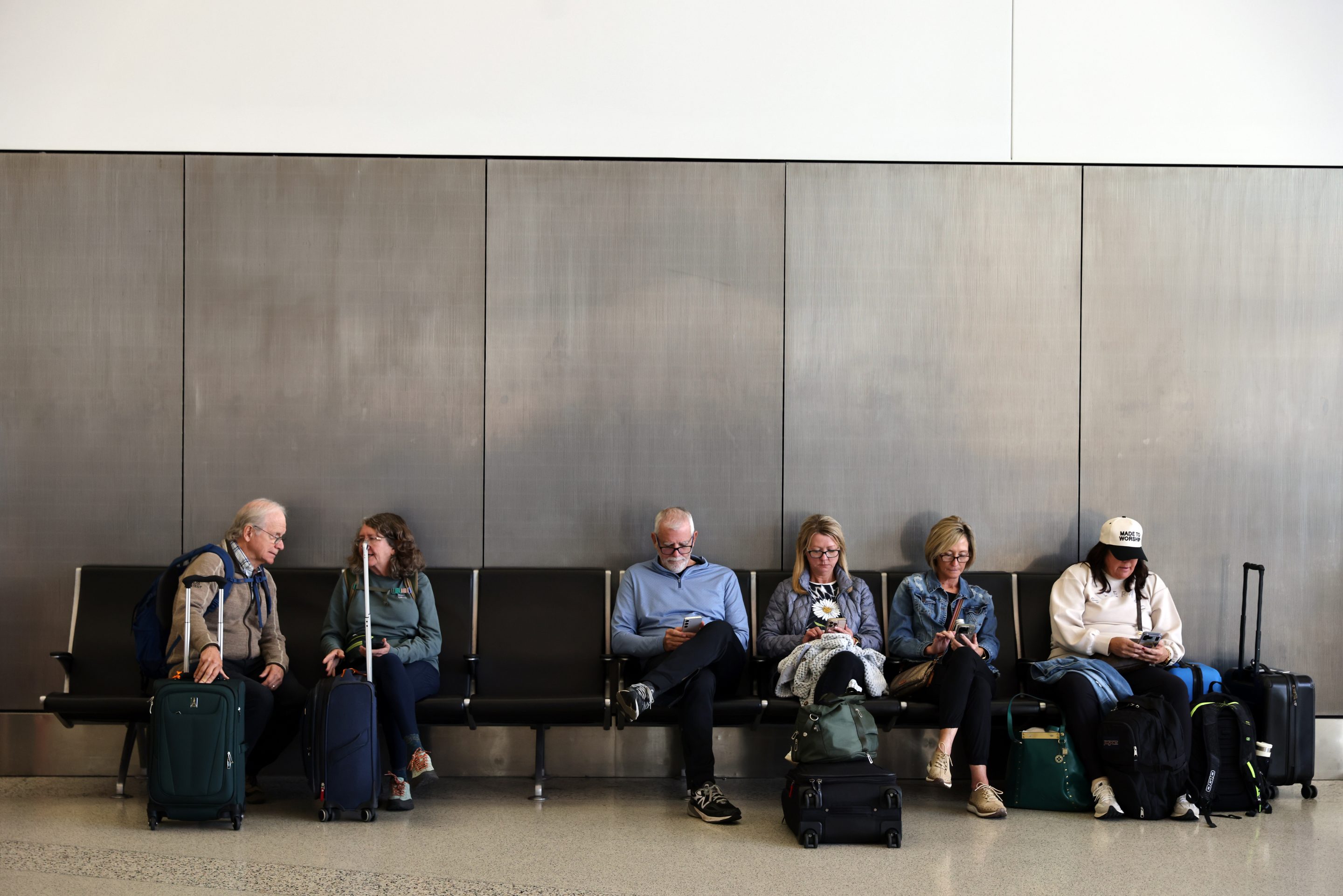 Travelers wait and check for their flights at San Francisco International Airport on Friday, Nov. 7, 2025.