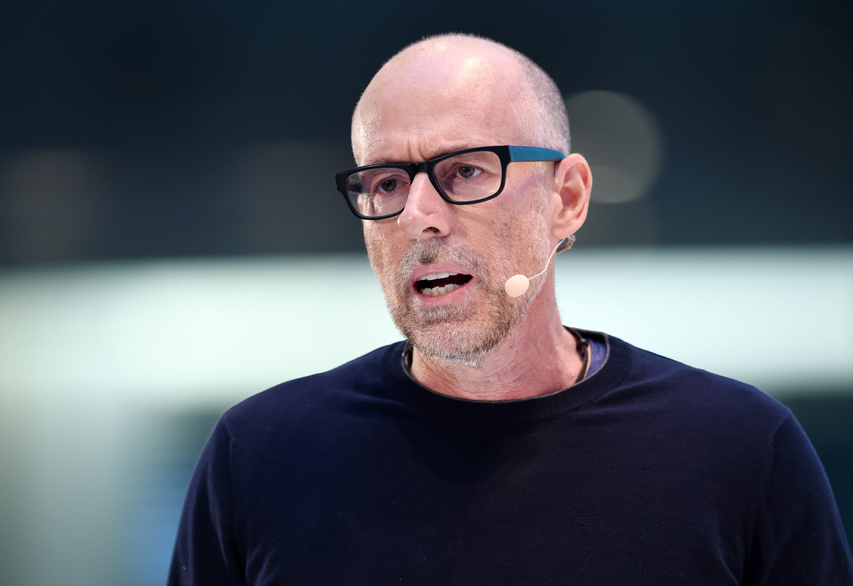 Scott Galloway speaks into a microphone at a conference